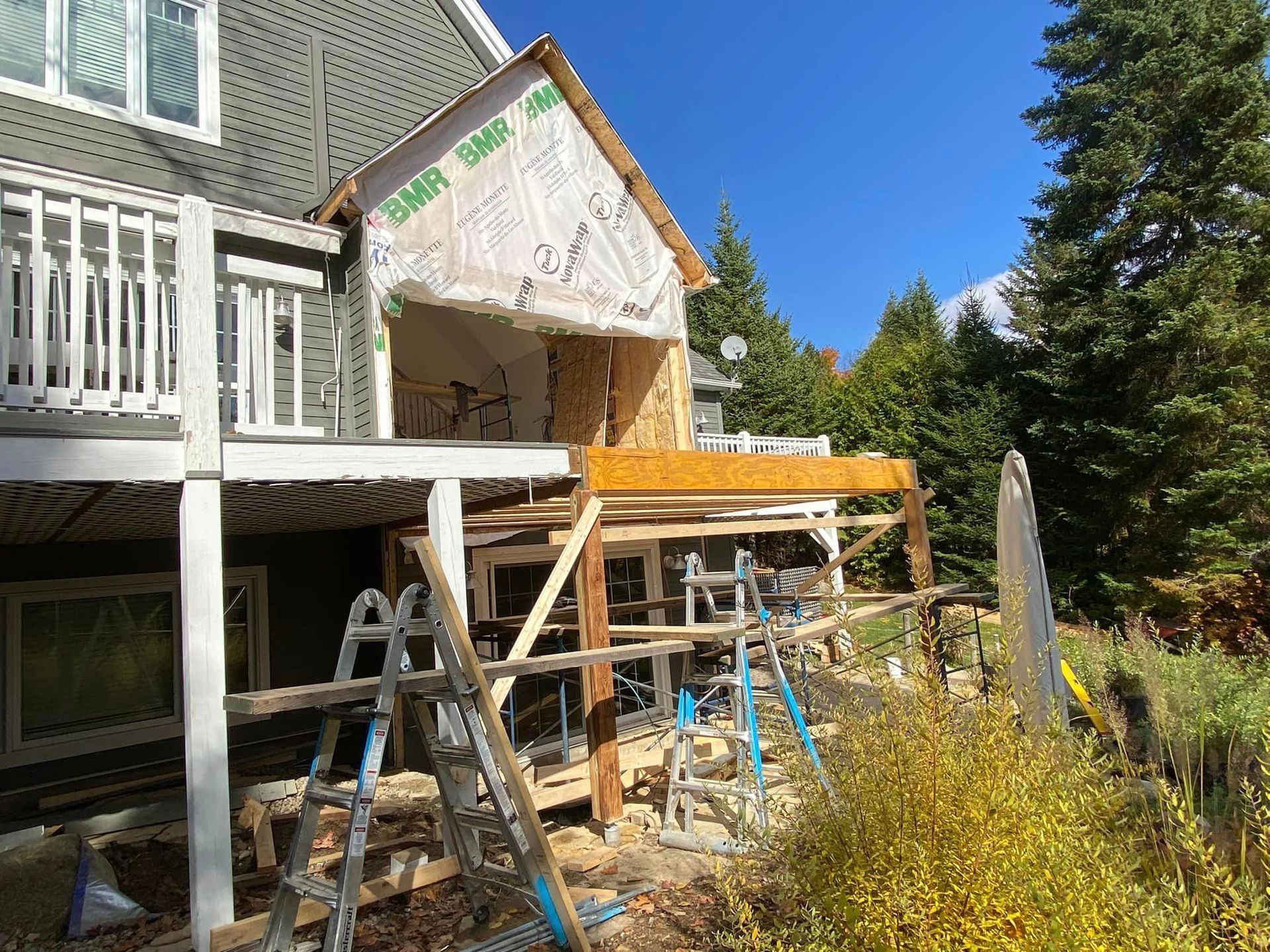 A house is being remodeled with a ladder in front of it.