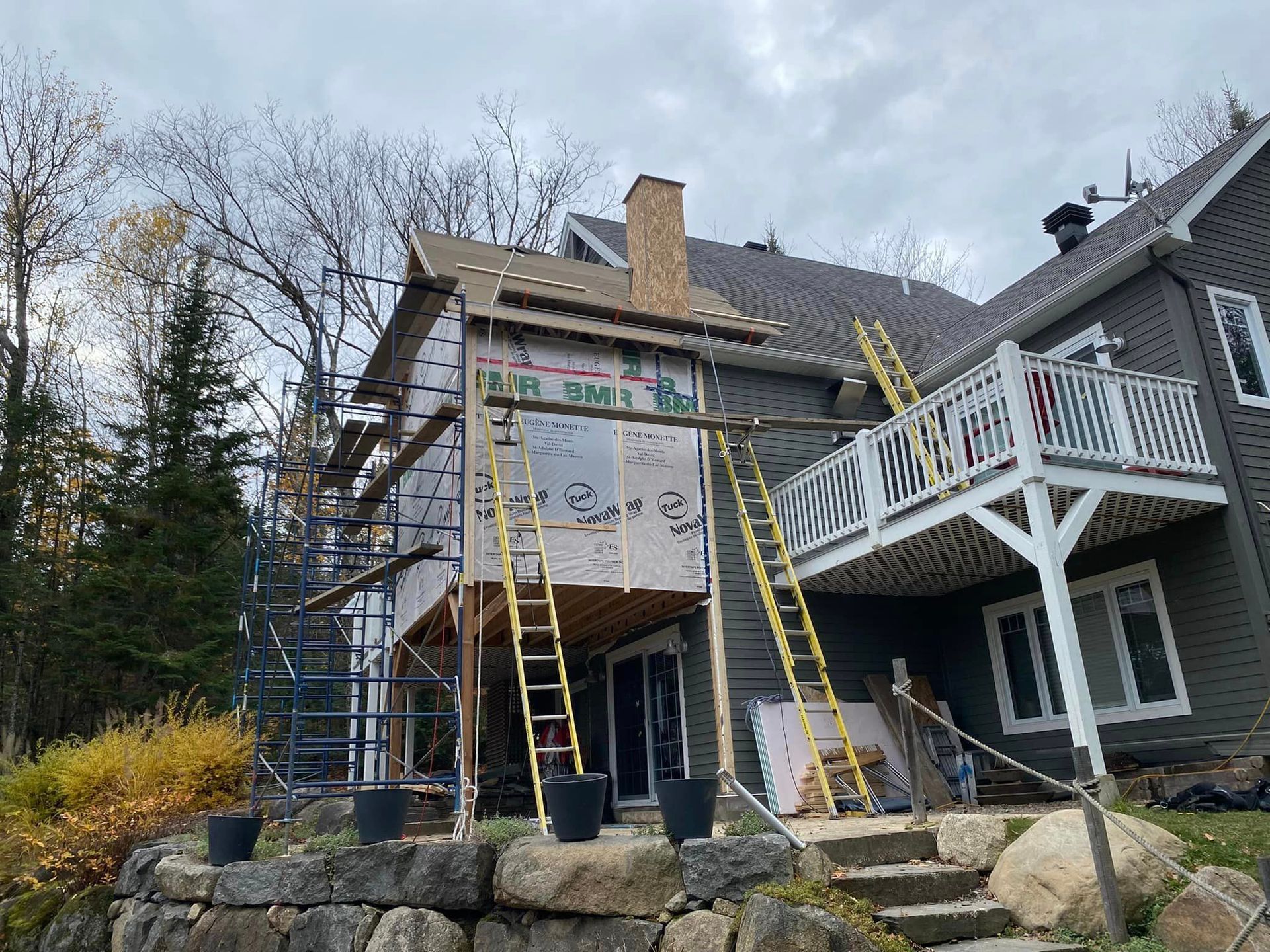 A house is being remodeled with a deck and scaffolding.