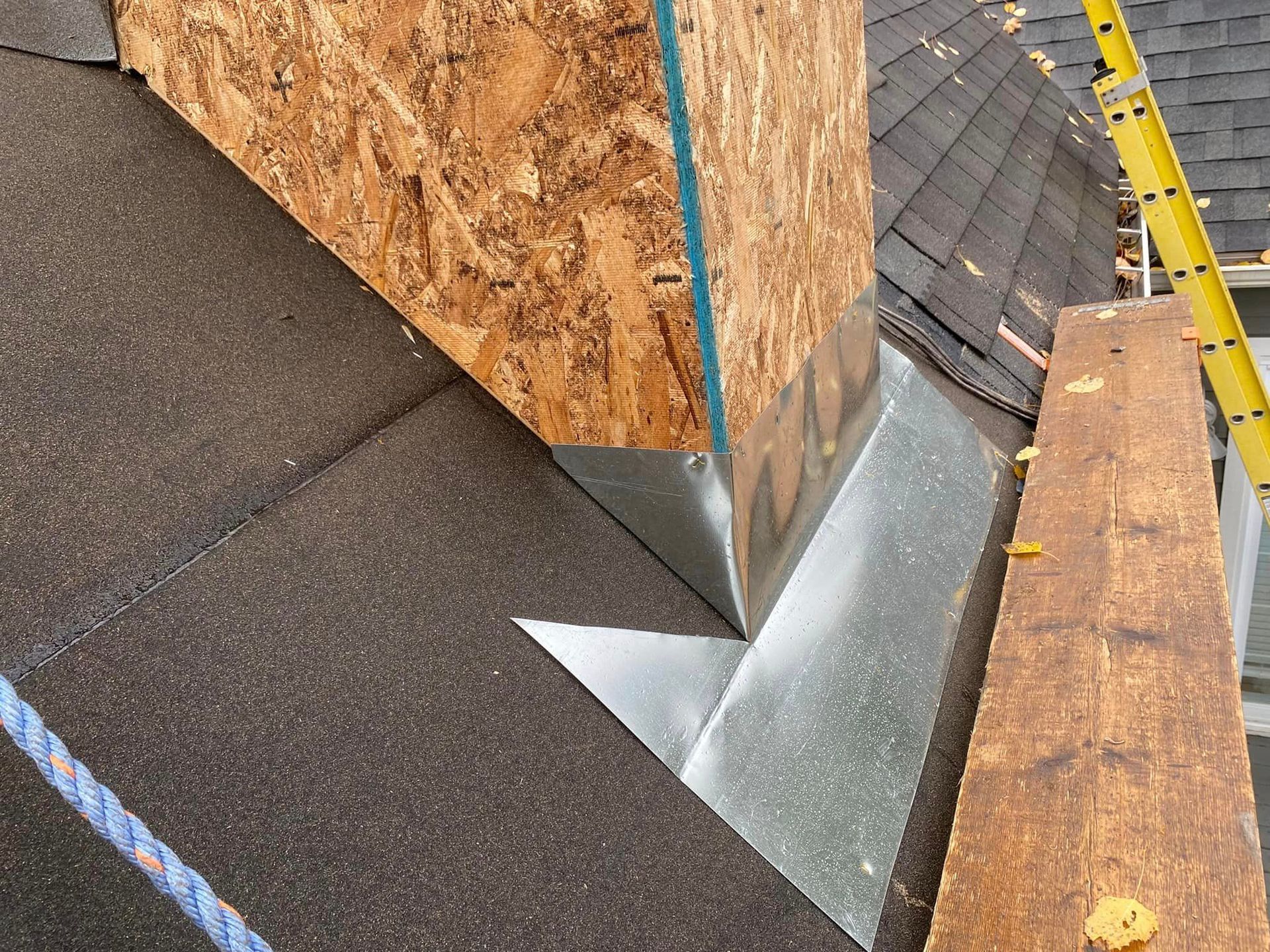 A close up of a roof with a ladder in the background