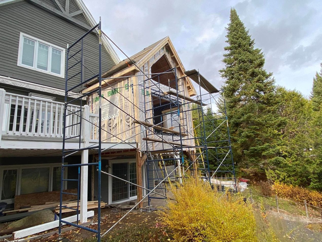 Une maison est en construction avec des échafaudages autour.