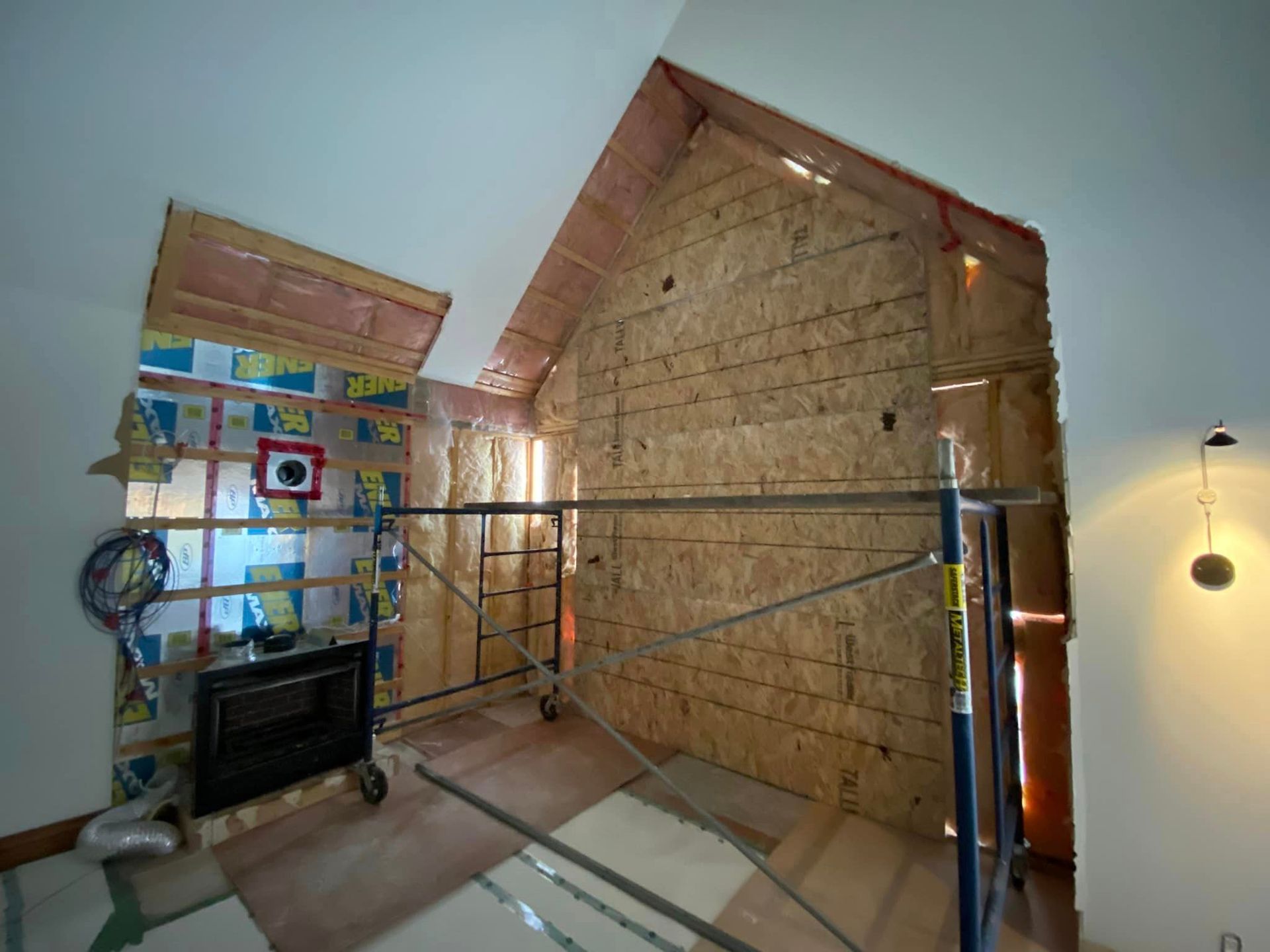 A room under construction with a fireplace and scaffolding