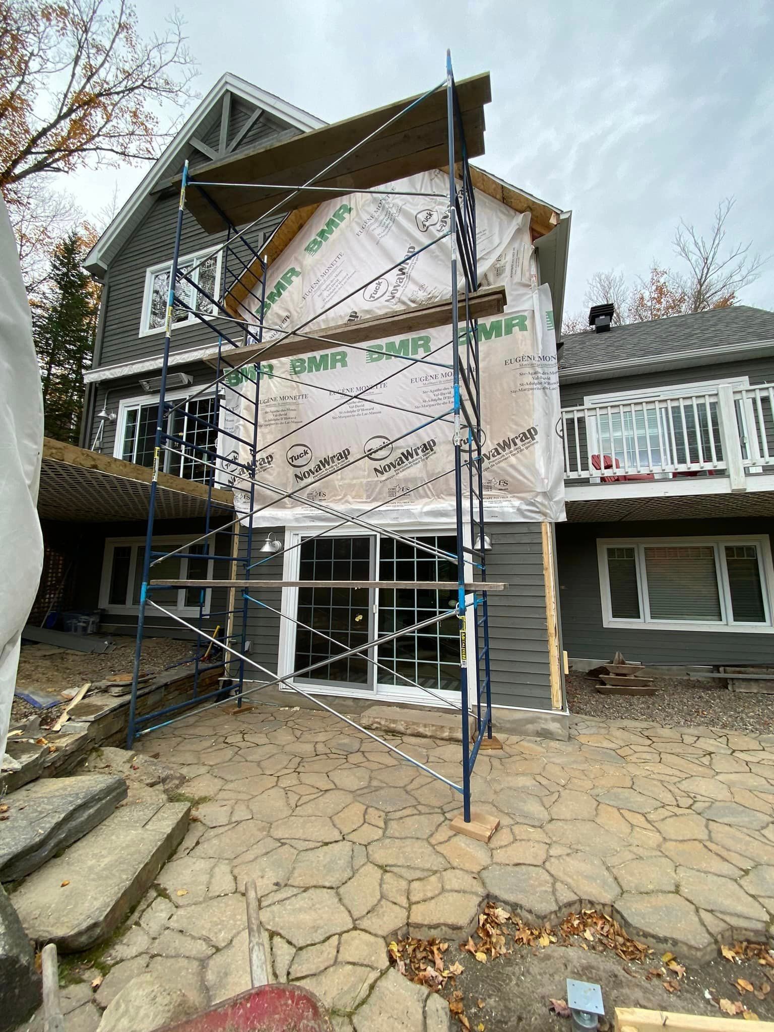 A large house is being remodeled with scaffolding around it.