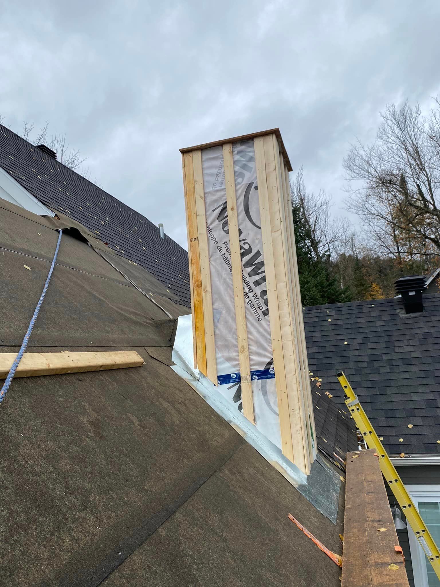 A chimney is being built on the roof of a house.