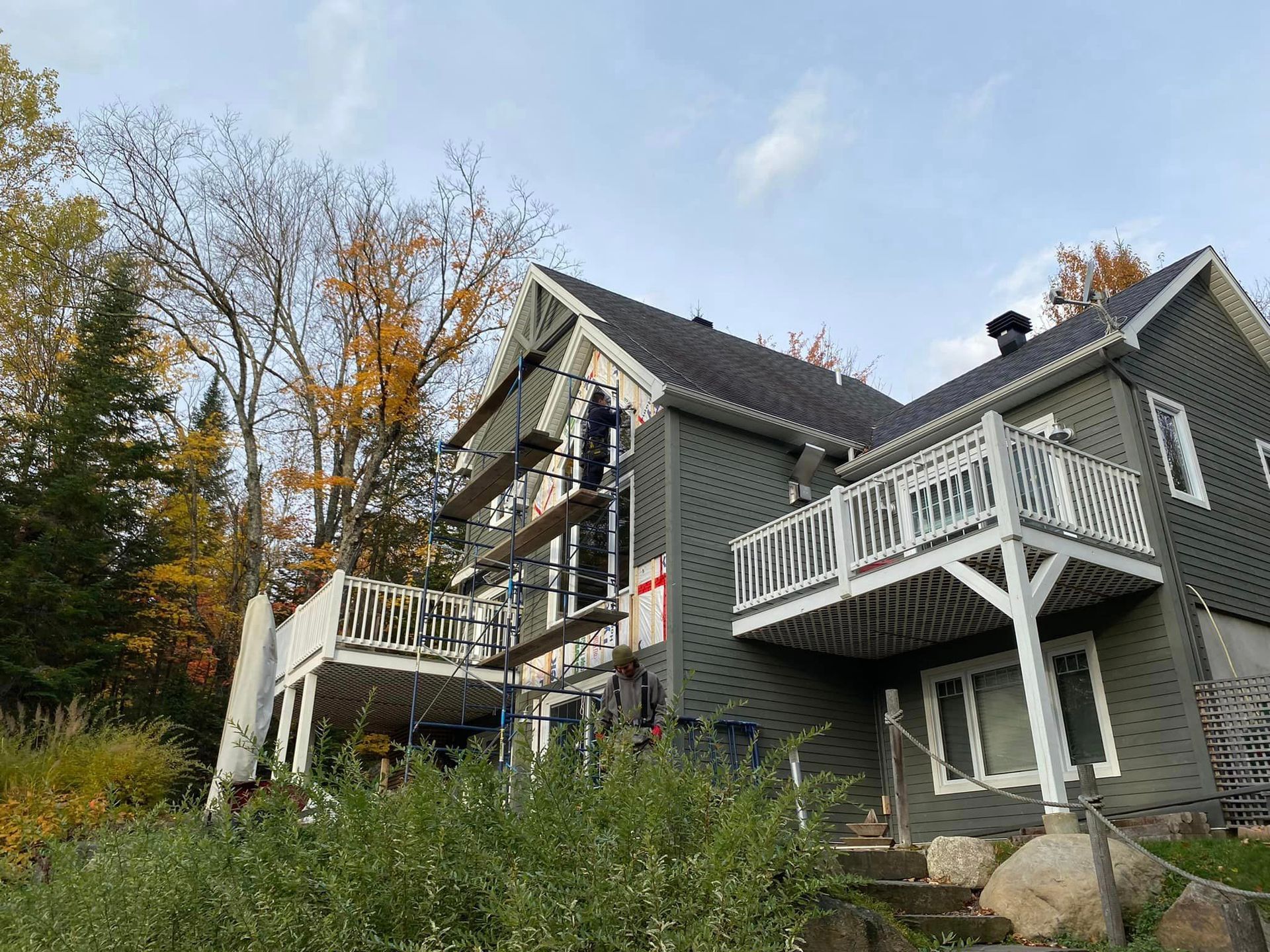 A large house with a balcony is being painted.