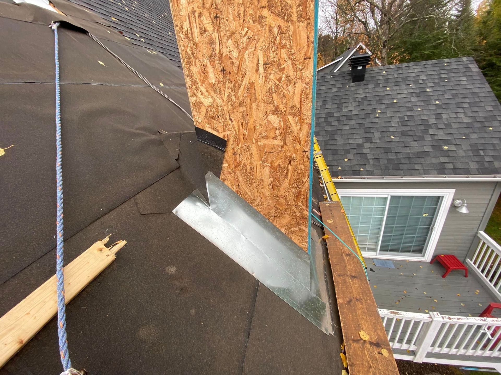 A chimney is being removed from the roof of a house