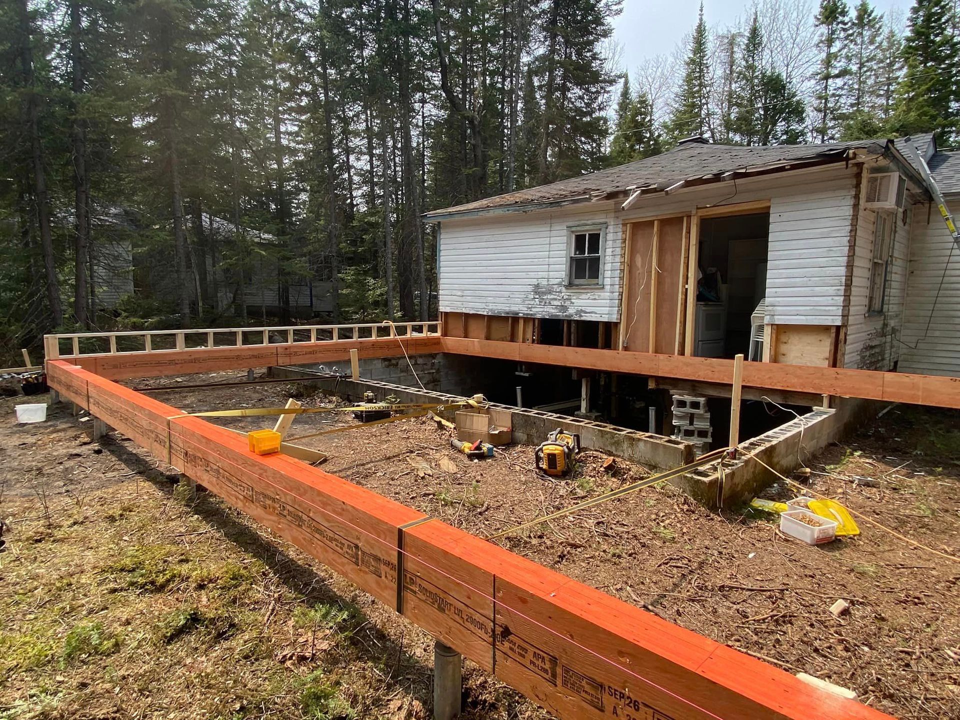 A house is being built on stilts in the middle of a forest.