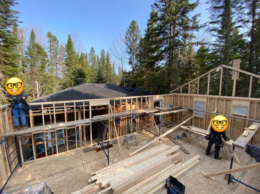 A house is being built in the woods with a lot of wood.