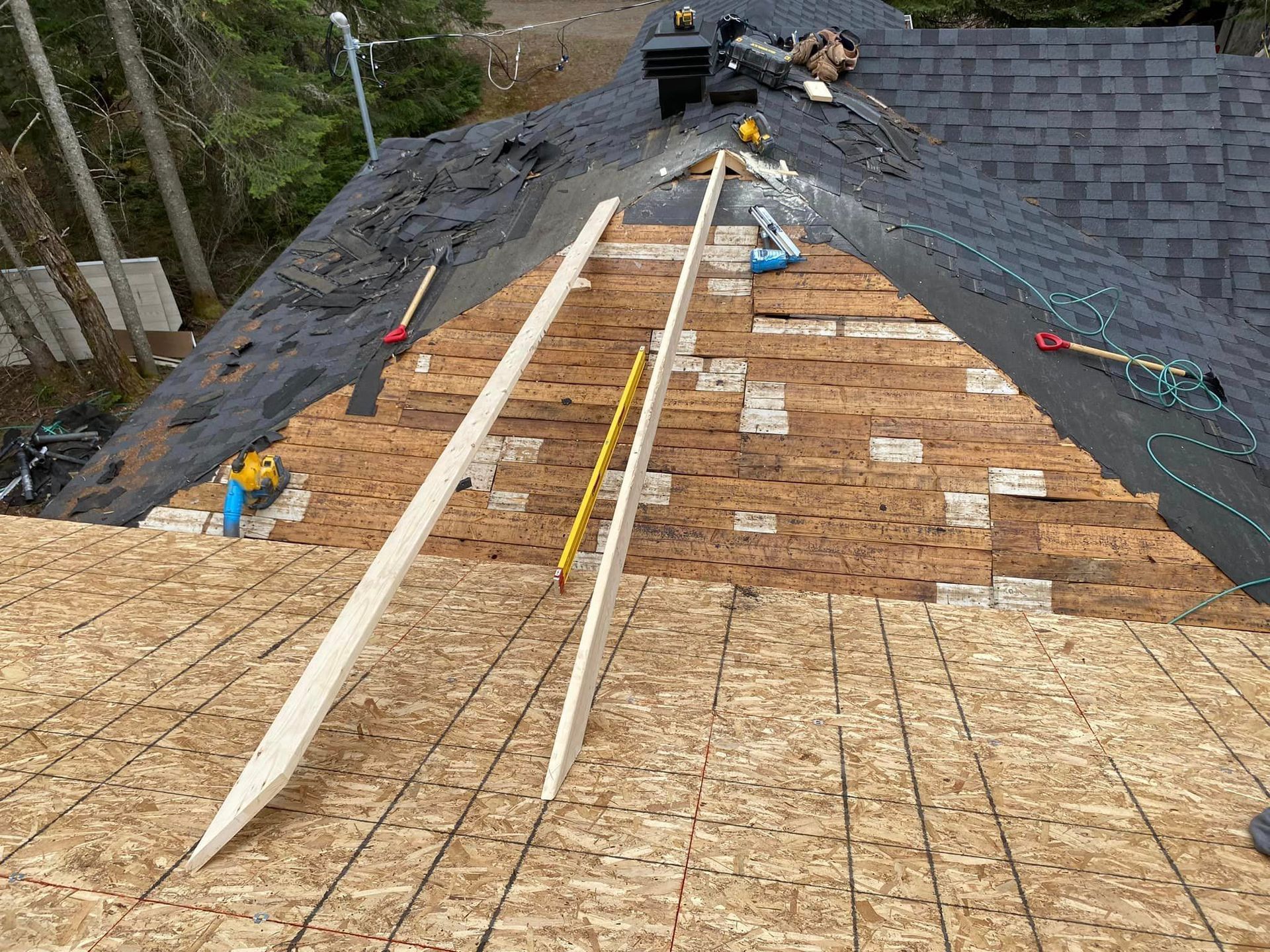 A roof is being built with shingles and plywood.