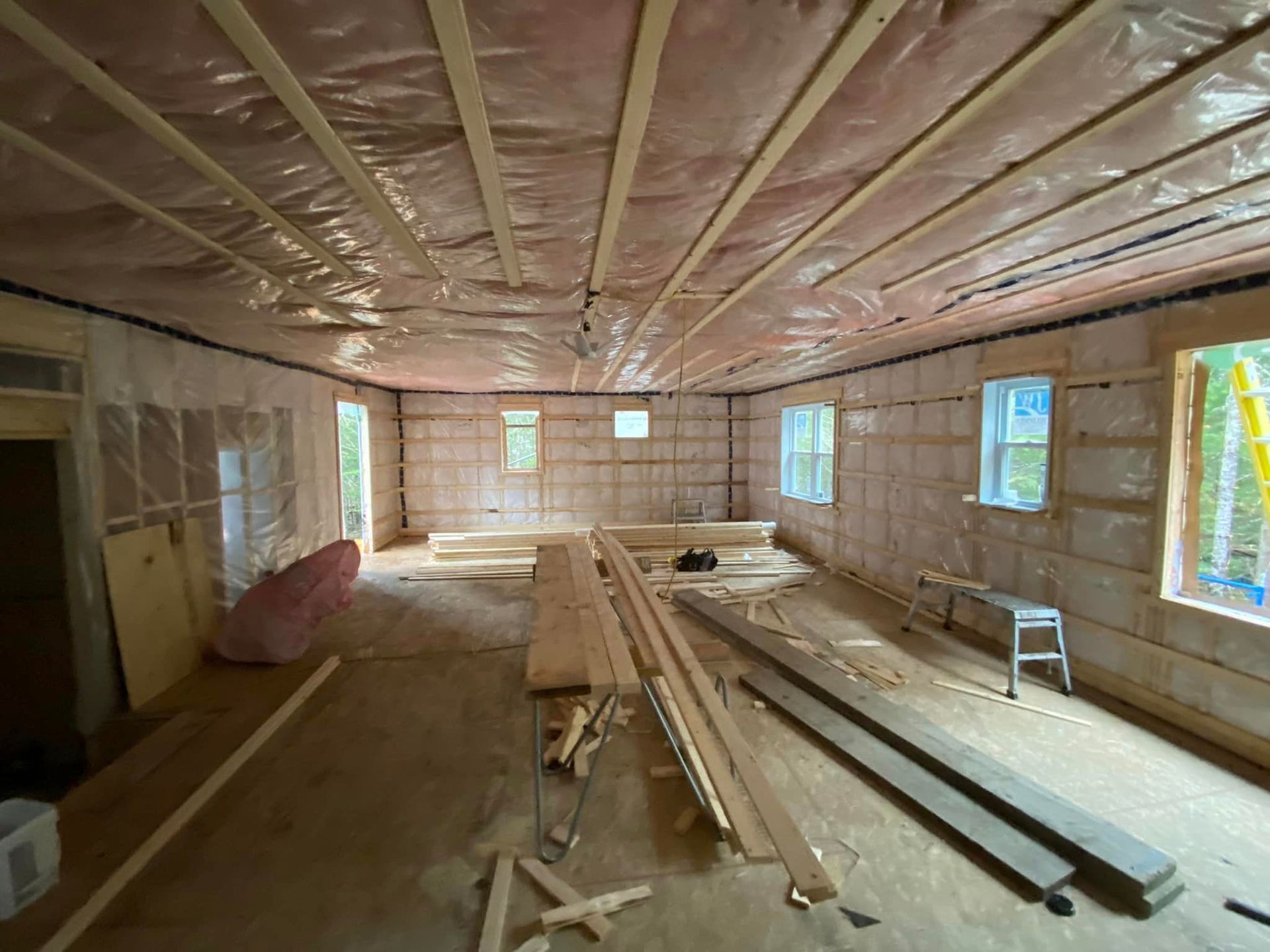 A room with a lot of wood and a ladder in it.
