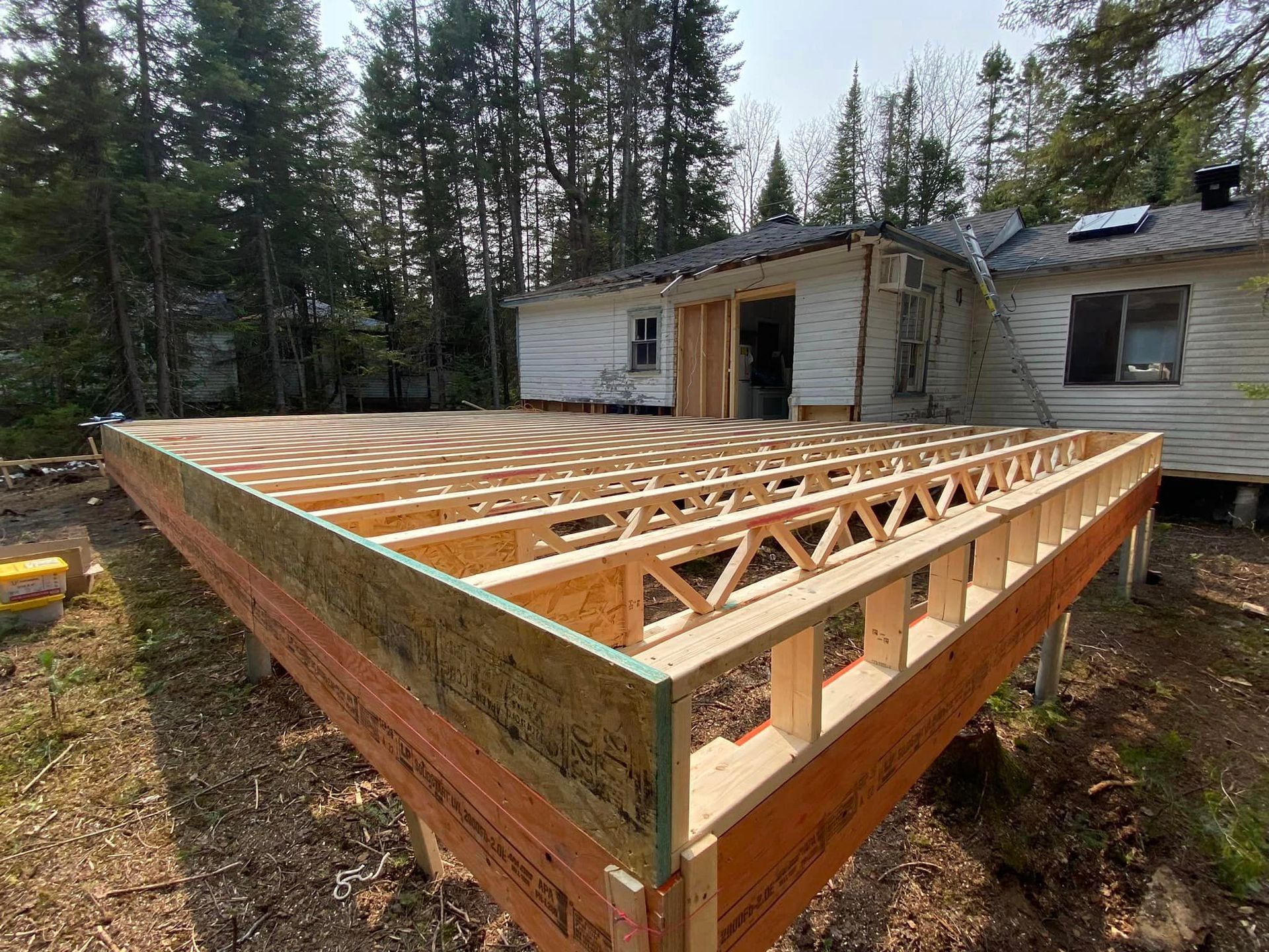 A wooden deck is being built in front of a house.