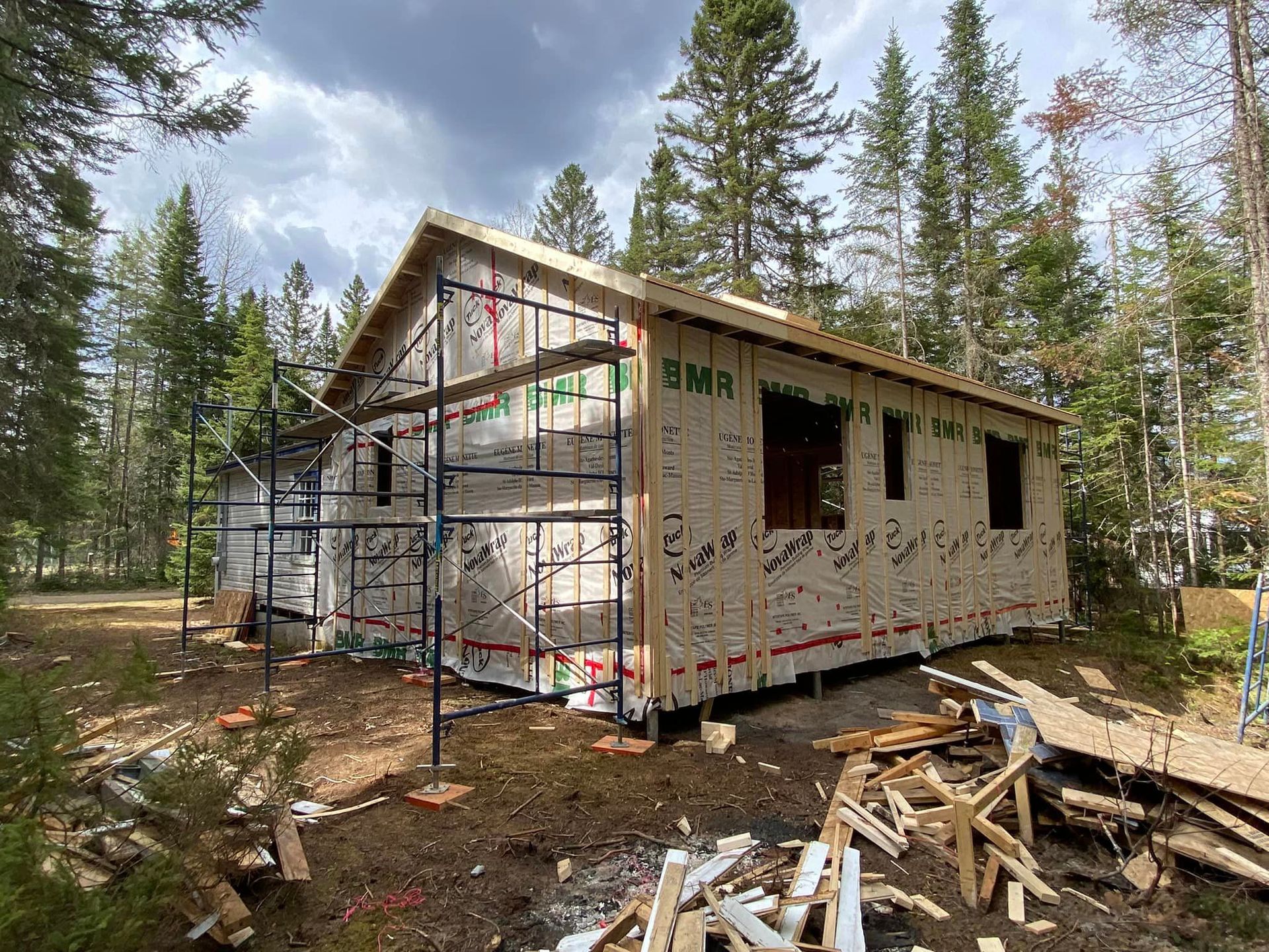 A small house is being built in the middle of a forest.