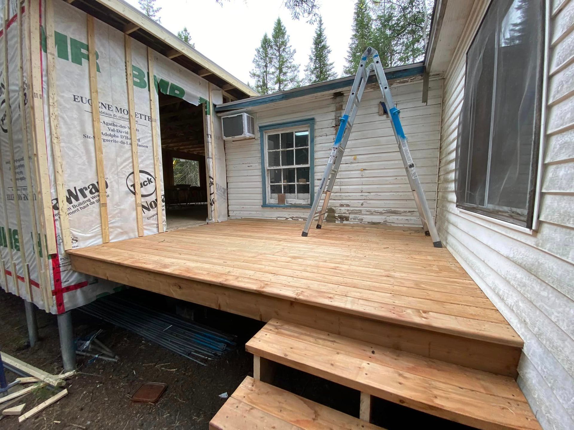 A wooden deck is being built on the side of a house.