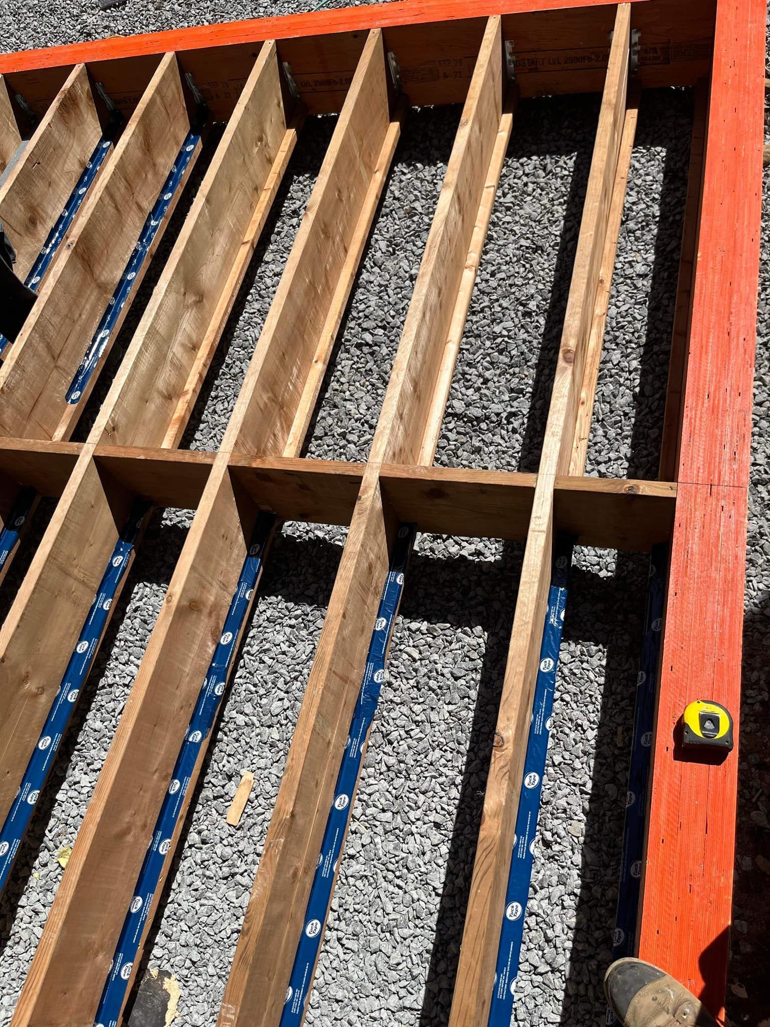 A person is measuring a wooden structure with a tape measure.