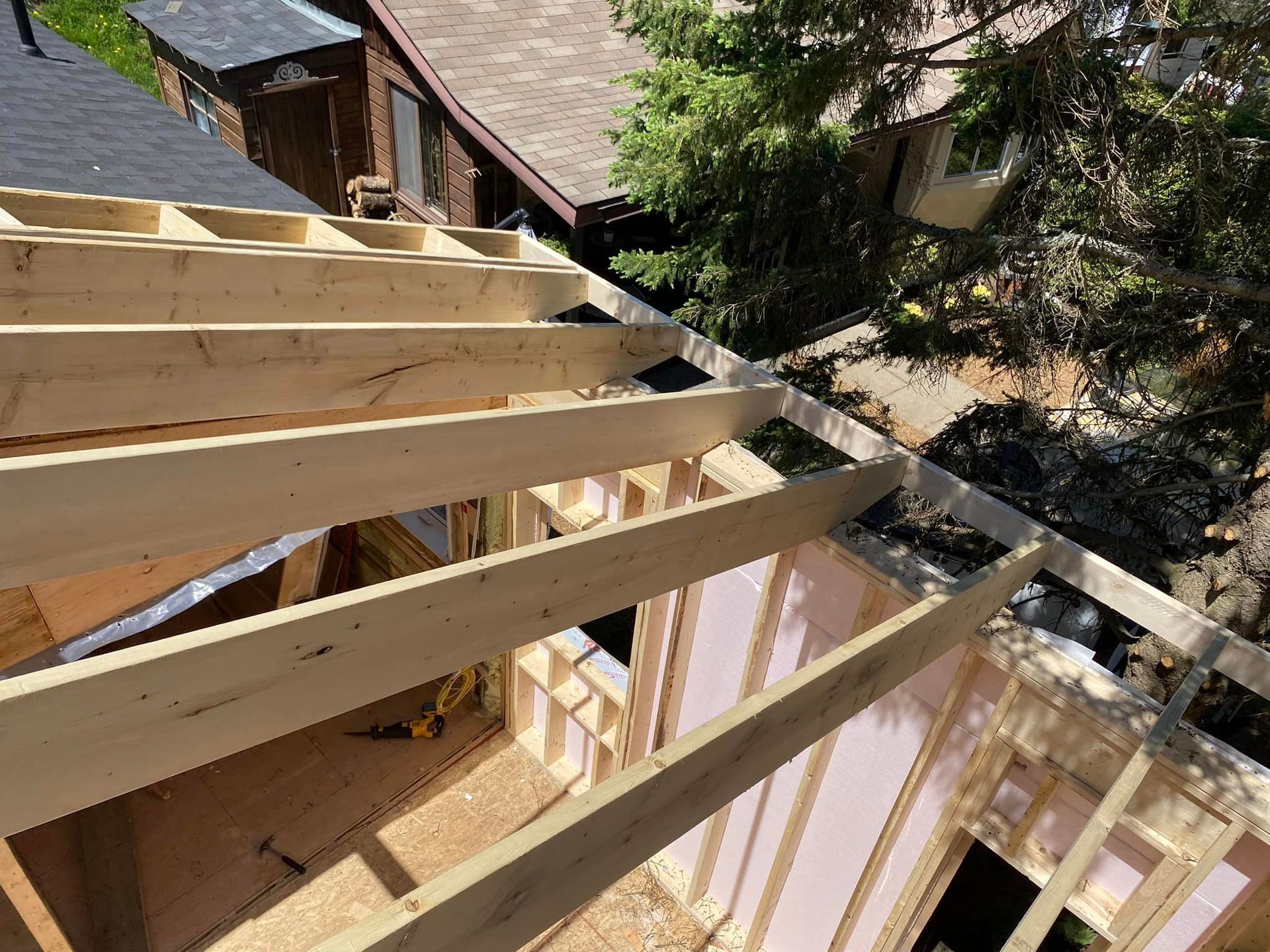 A house is being built with wooden beams and a roof.