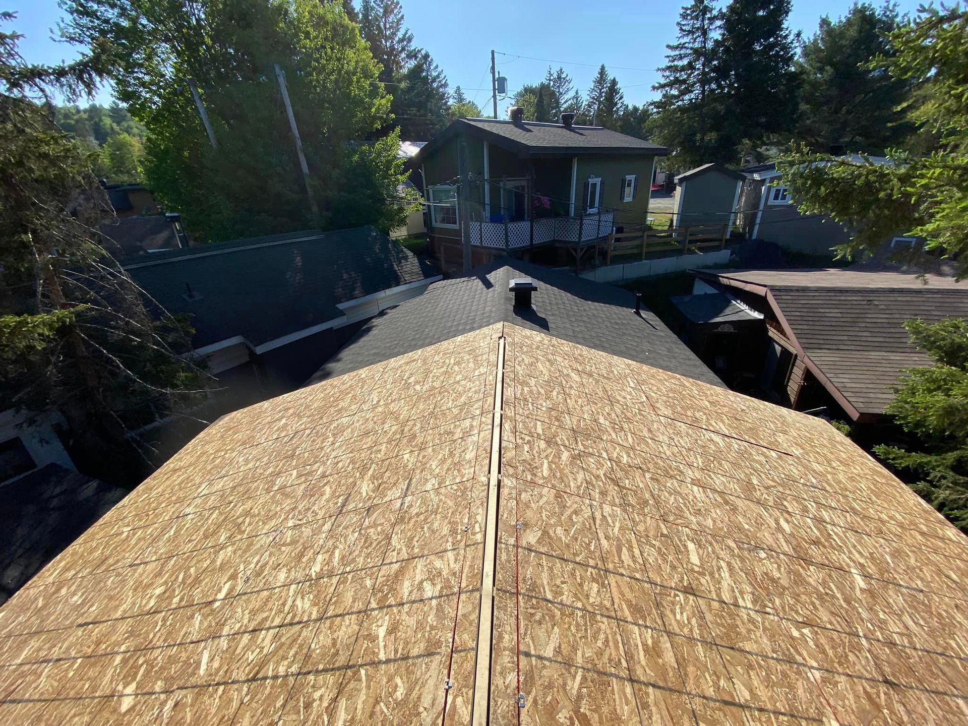 The roof of a house is being covered with plywood.