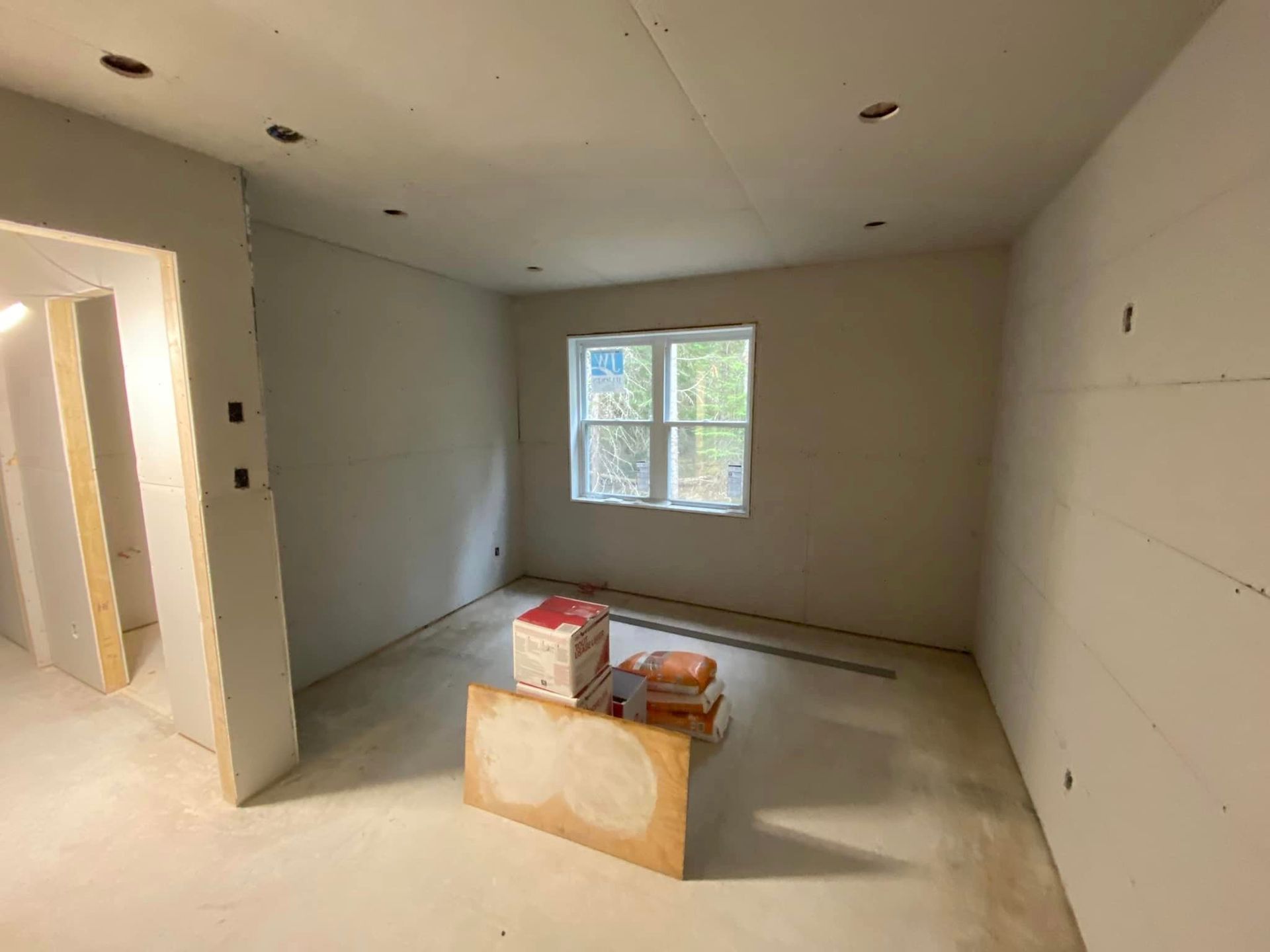 A room that is being remodeled with drywall and a window.