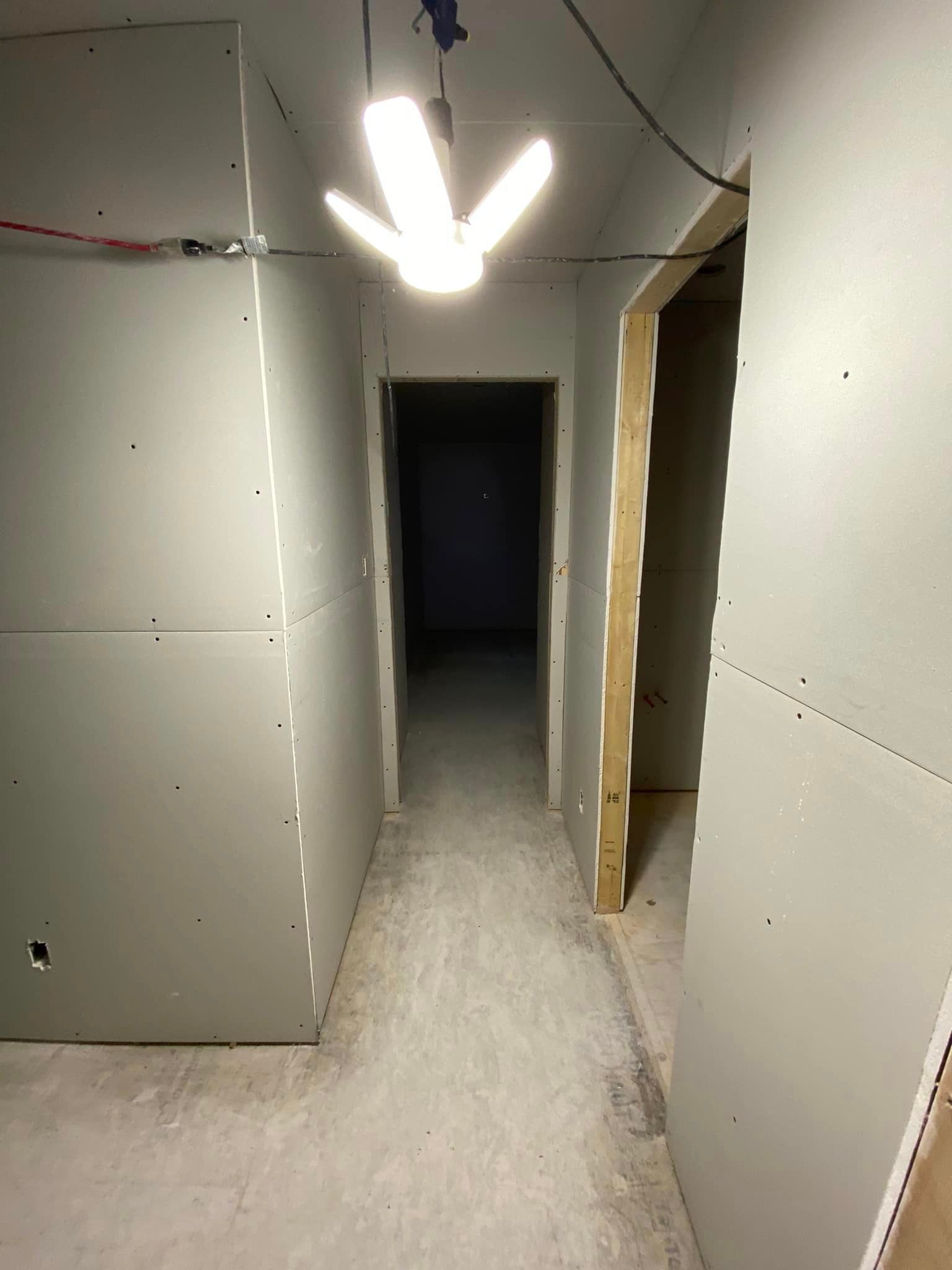 A long hallway with a light hanging from the ceiling.