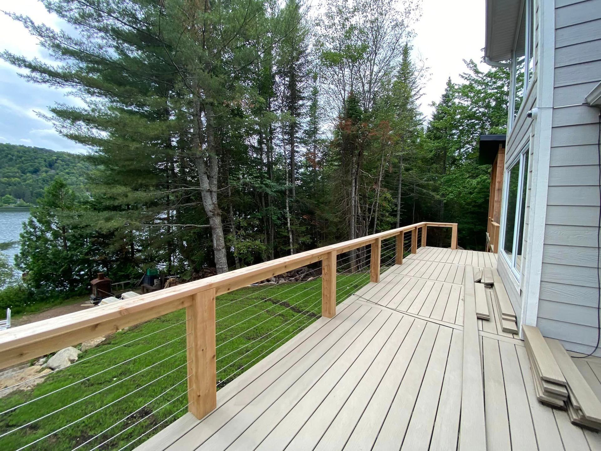 A wooden deck with a metal railing overlooking a lake