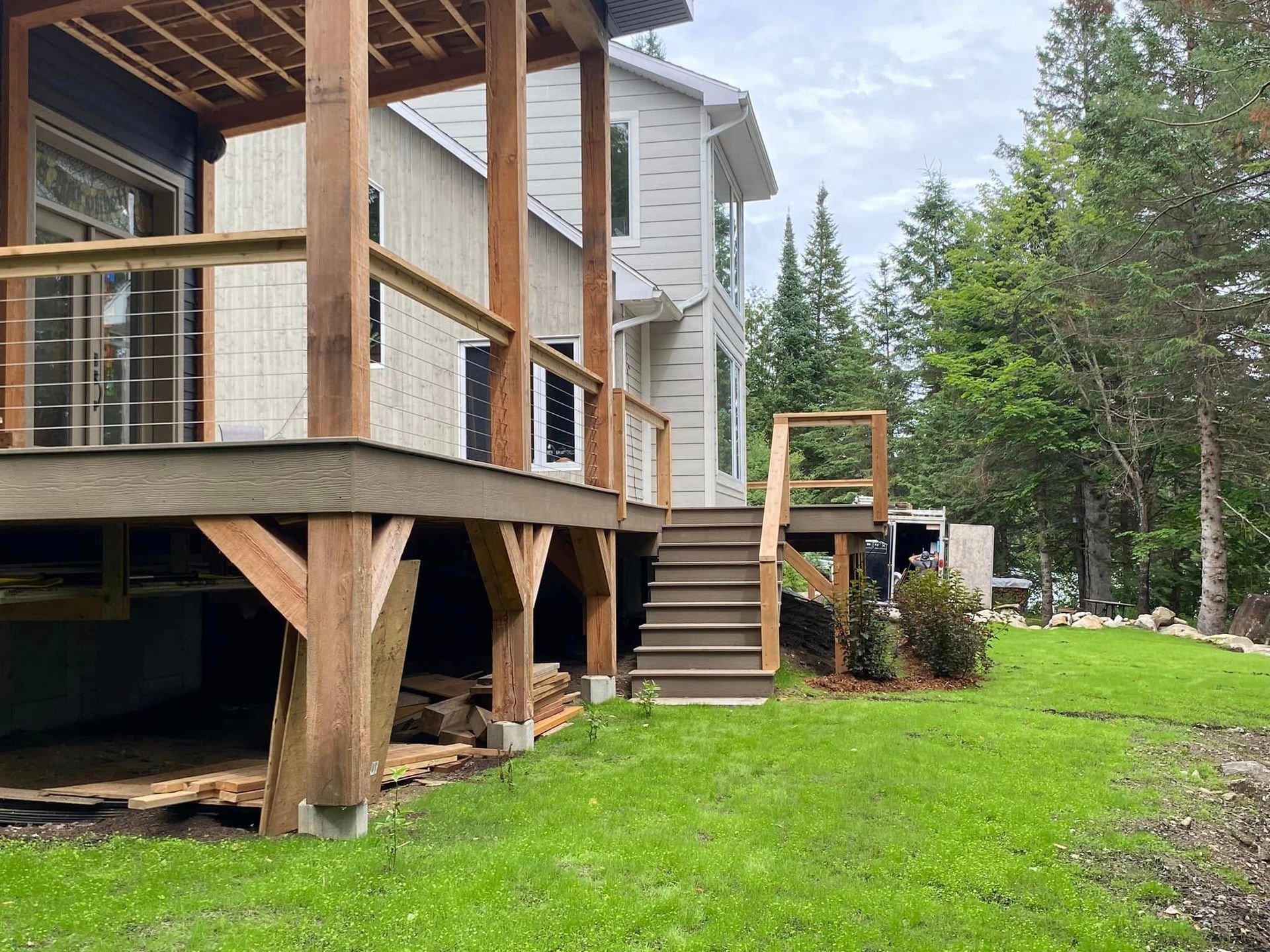 A house with a large deck and stairs in the backyard.