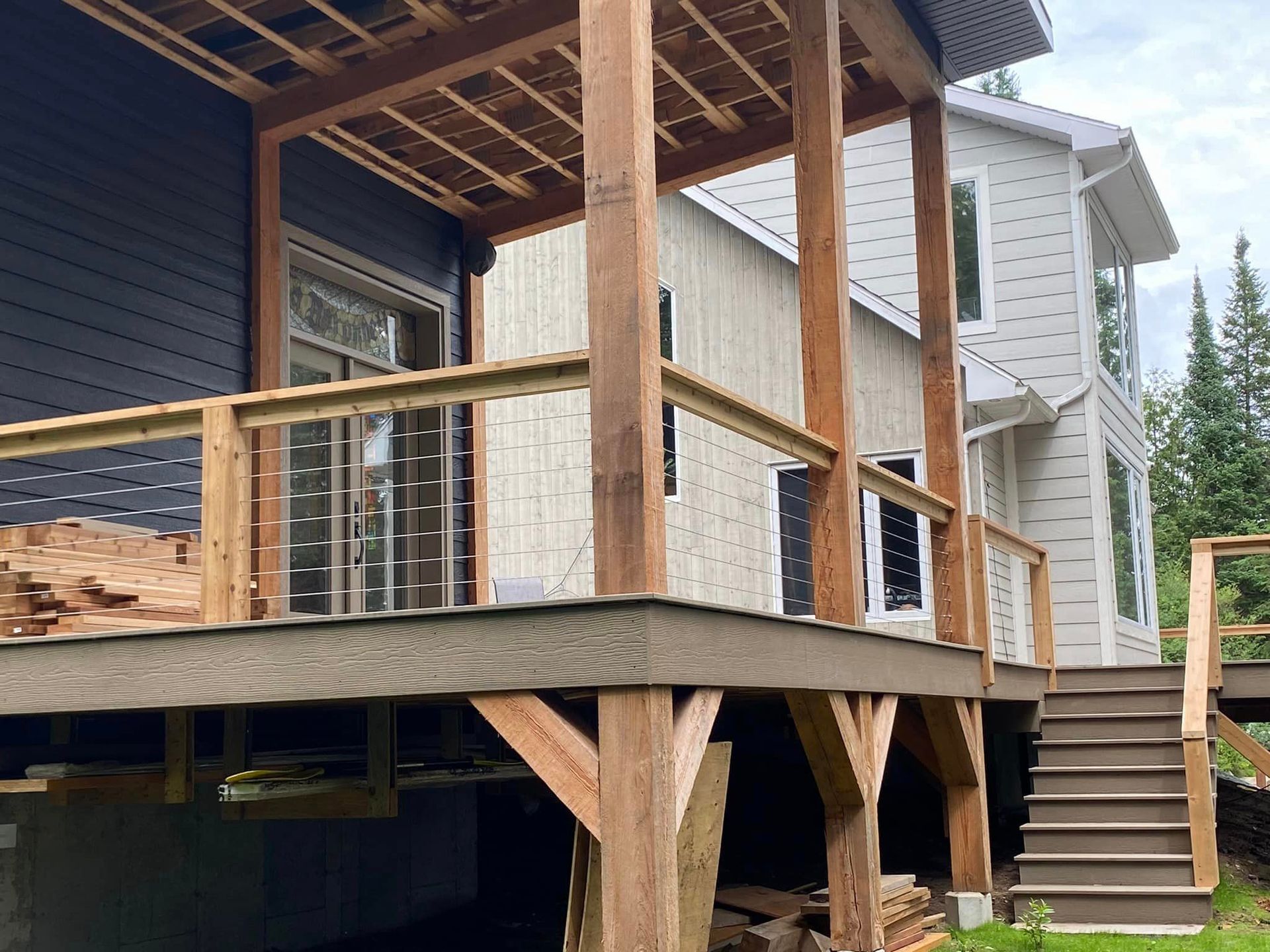 A house with a wooden deck and stairs in front of it.