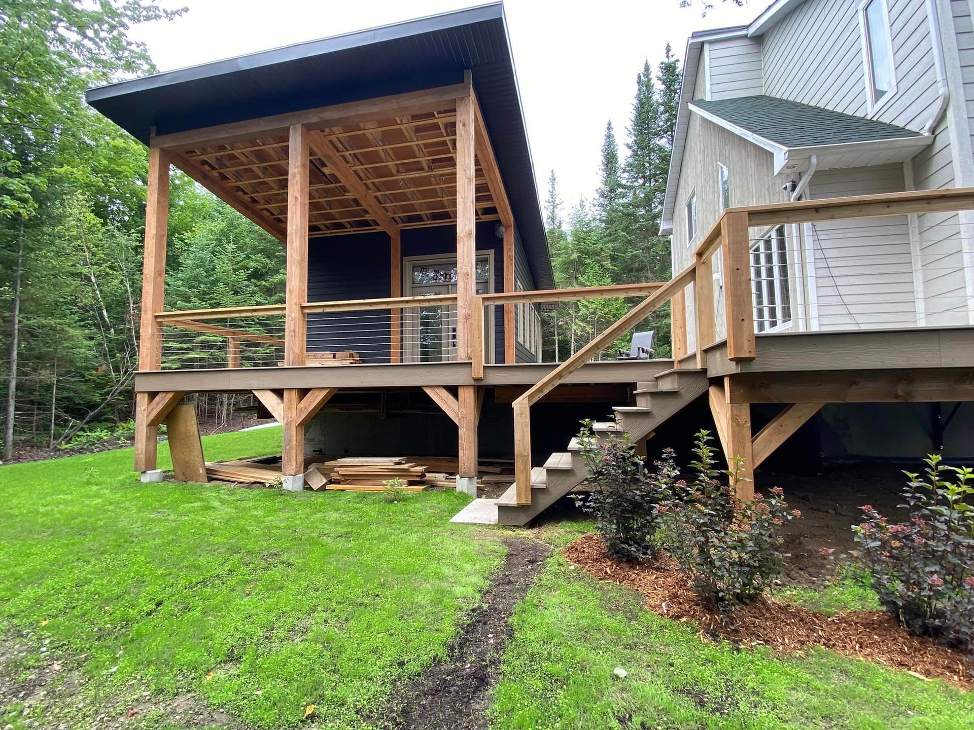 A house with a large deck and stairs in the backyard.