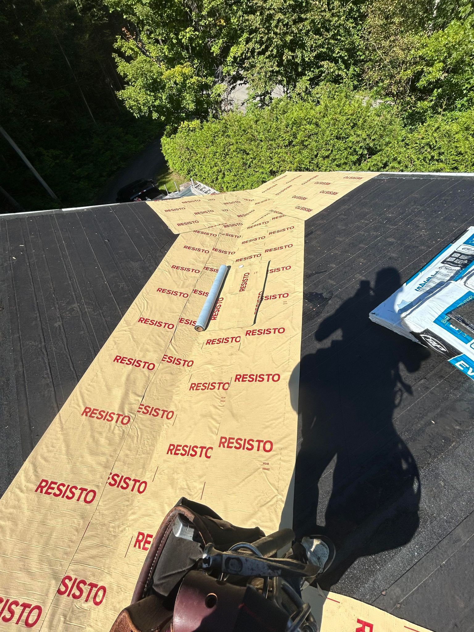 A person is standing on a roof with a shadow on it.