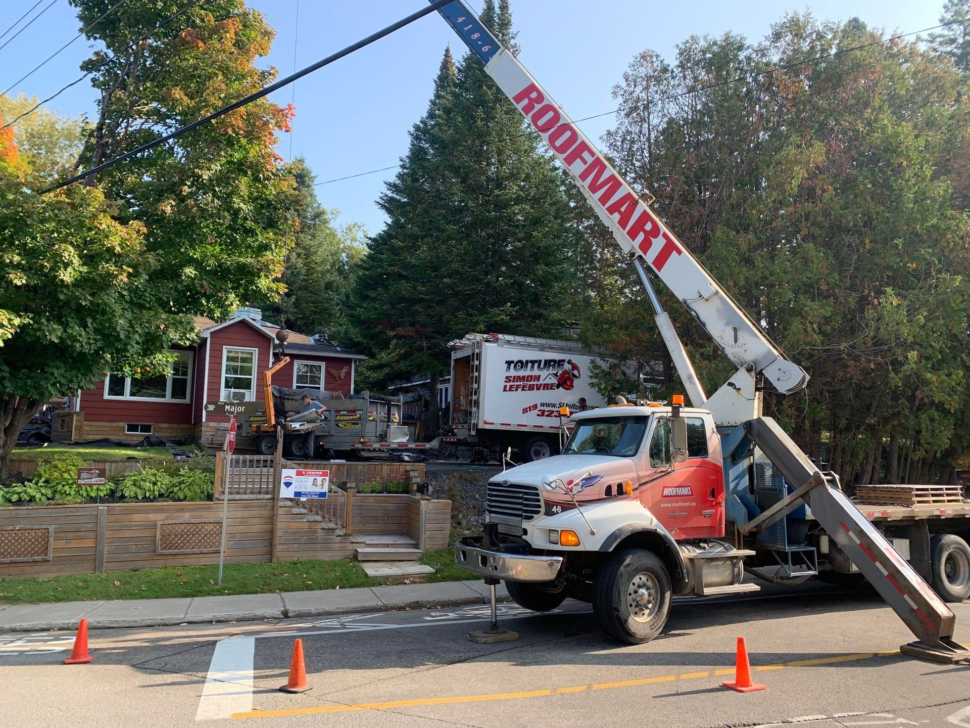 A roofmart truck is parked on the side of the road.