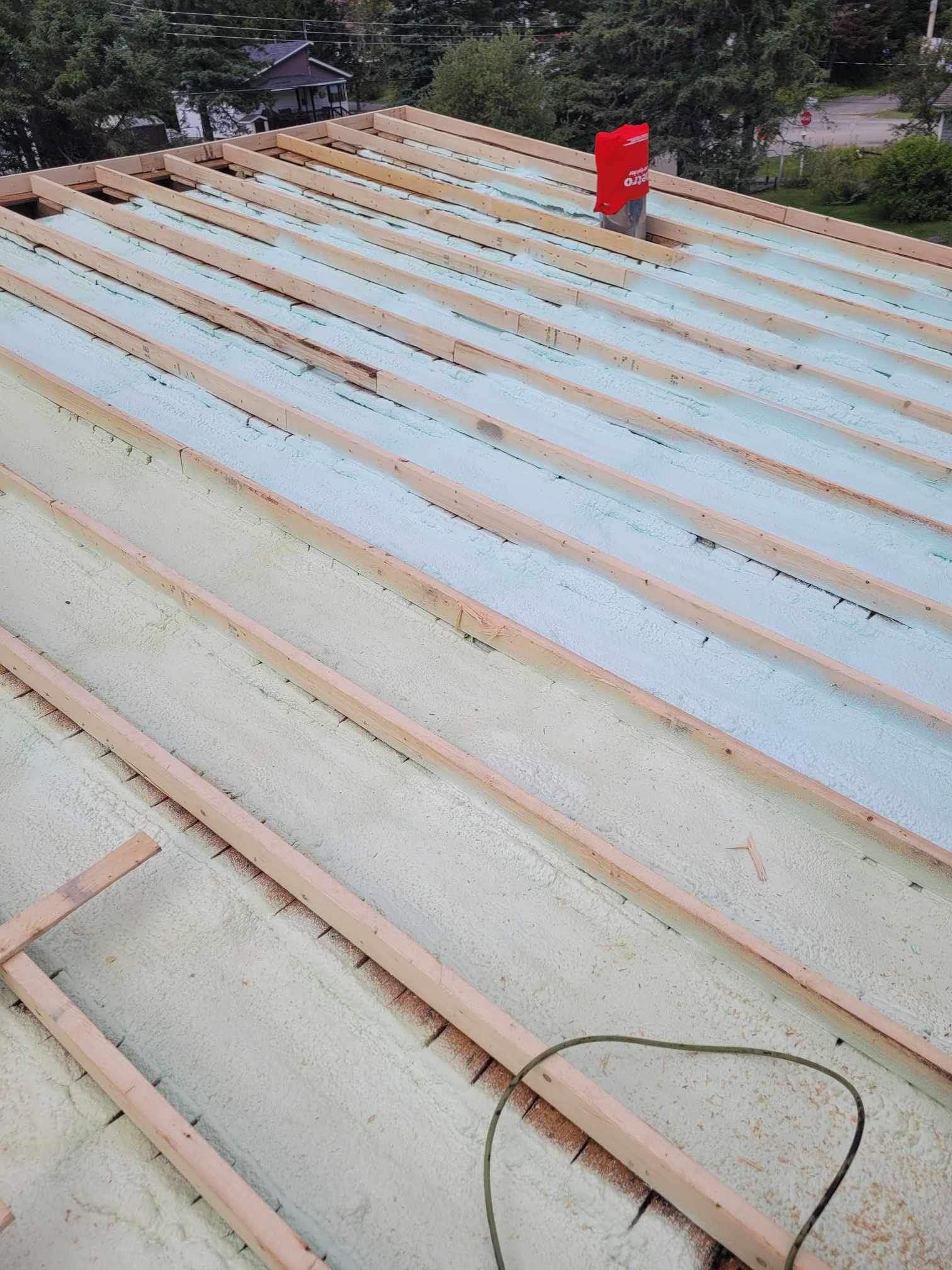 A roof is being built with wooden beams and foam.