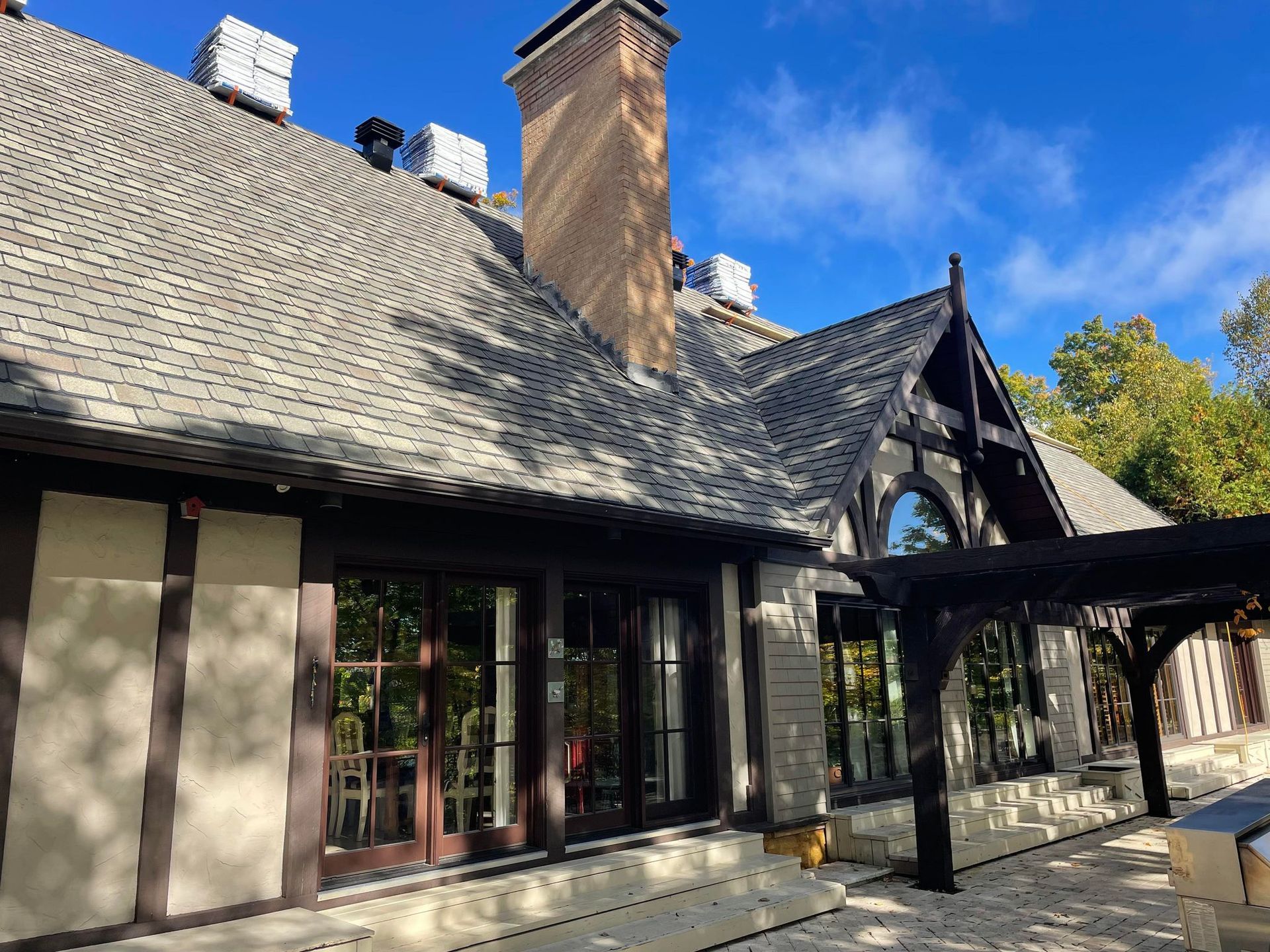 A large house with a lot of windows and a chimney on the roof.