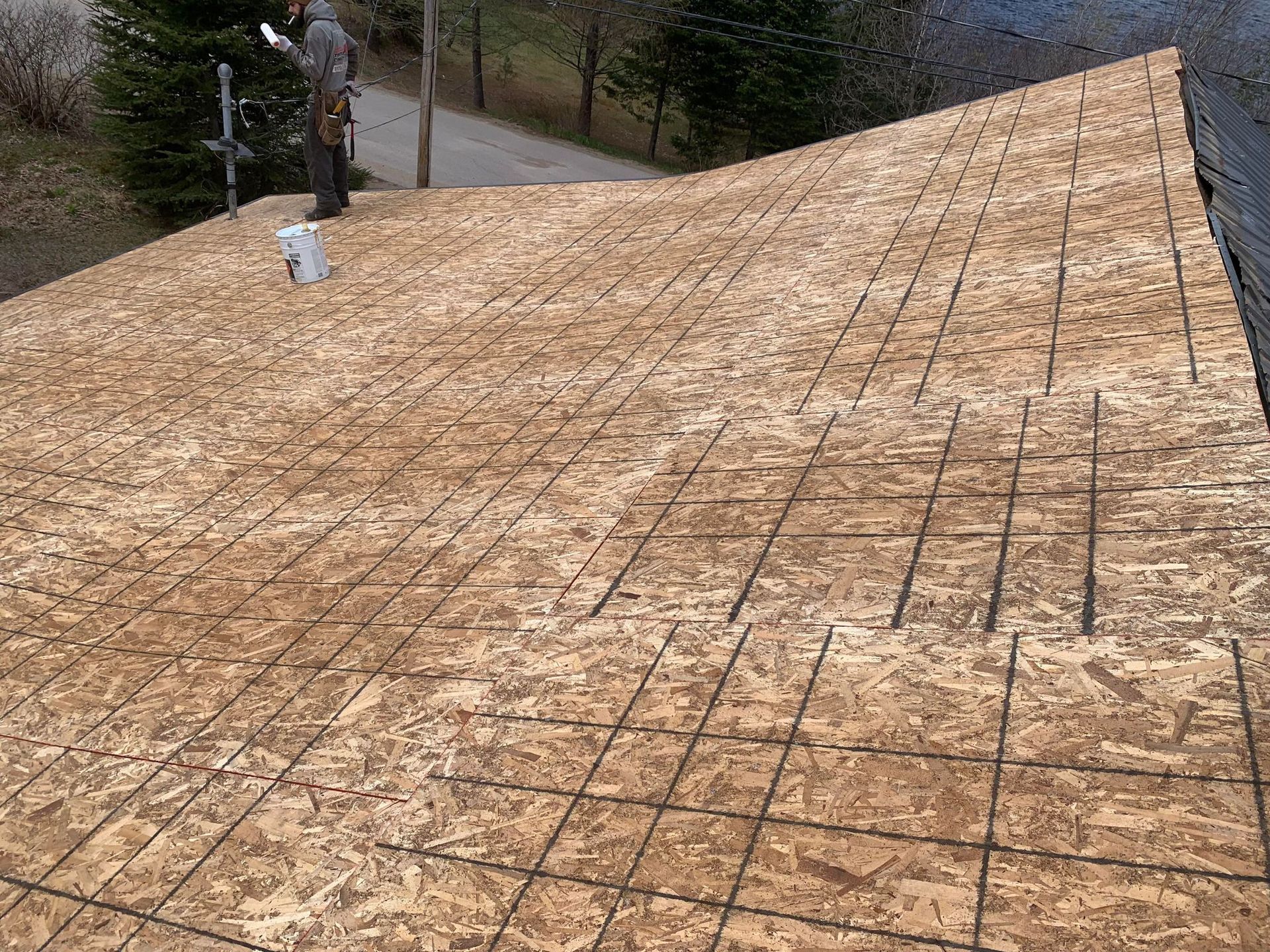 A man is standing on top of a wooden roof.