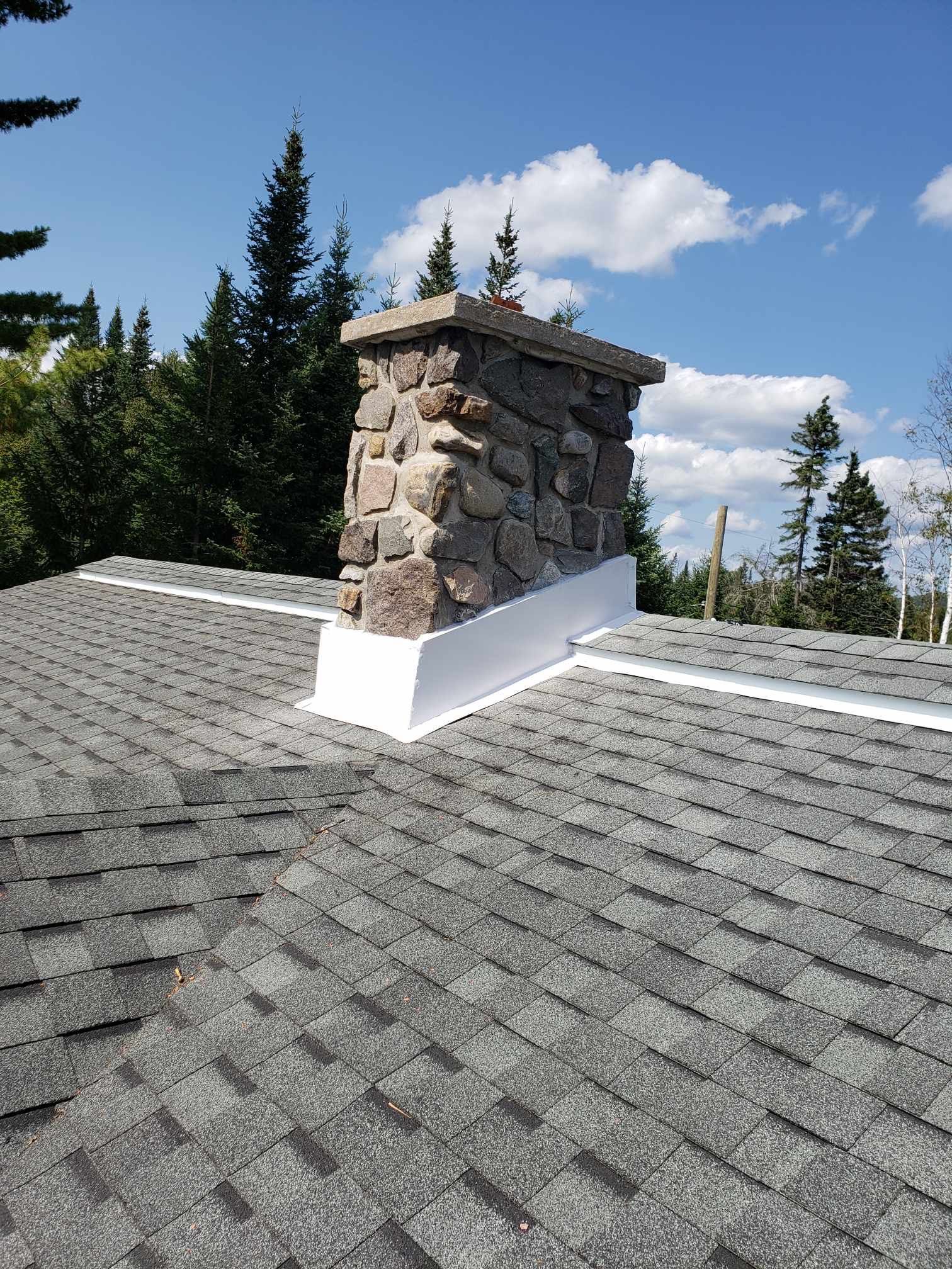 There is a chimney on the roof of a house.
