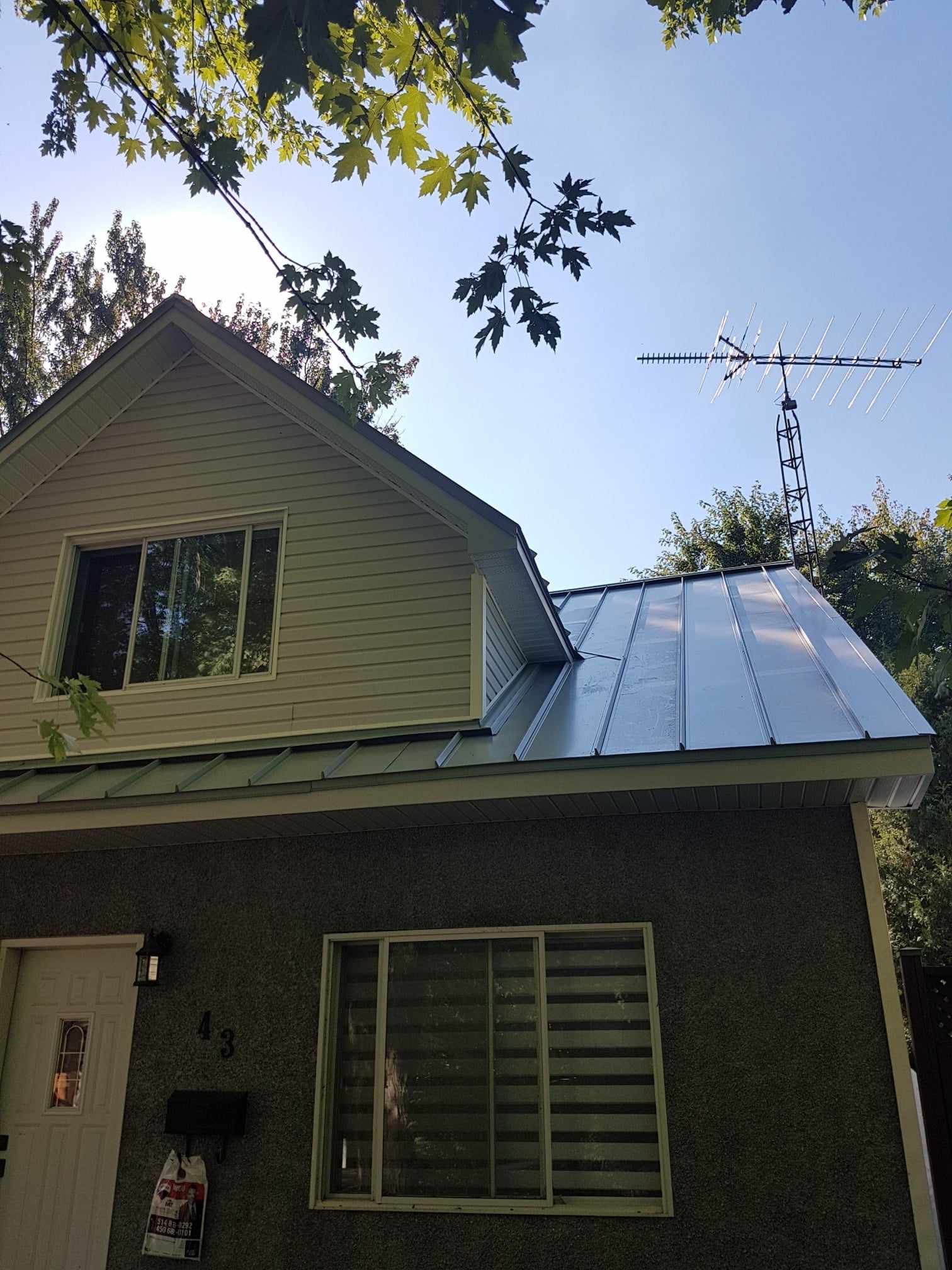 A house with a metal roof and a windmill on top of it