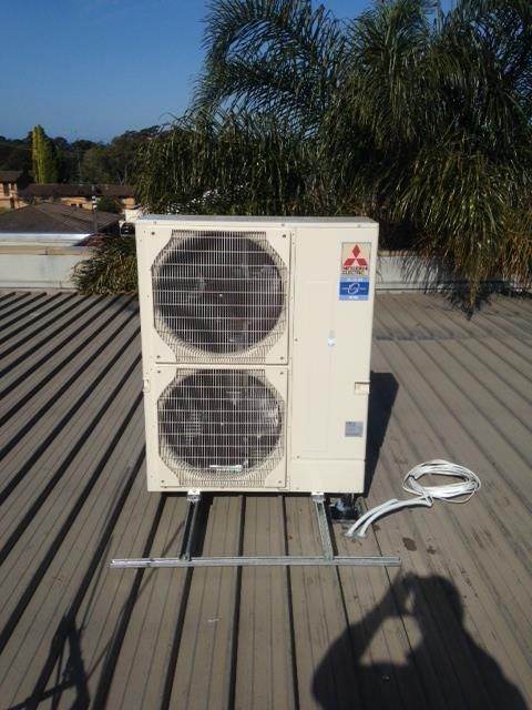 A mitsubishi air conditioner is sitting on top of a roof — Commercial Air Conditioning Hunter Valley