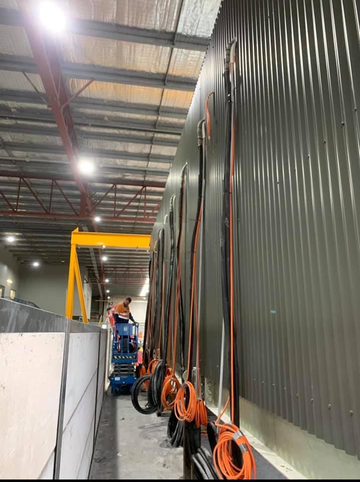 A man is working on a crane in a warehouse — Air Conditioning Lake Macquarie