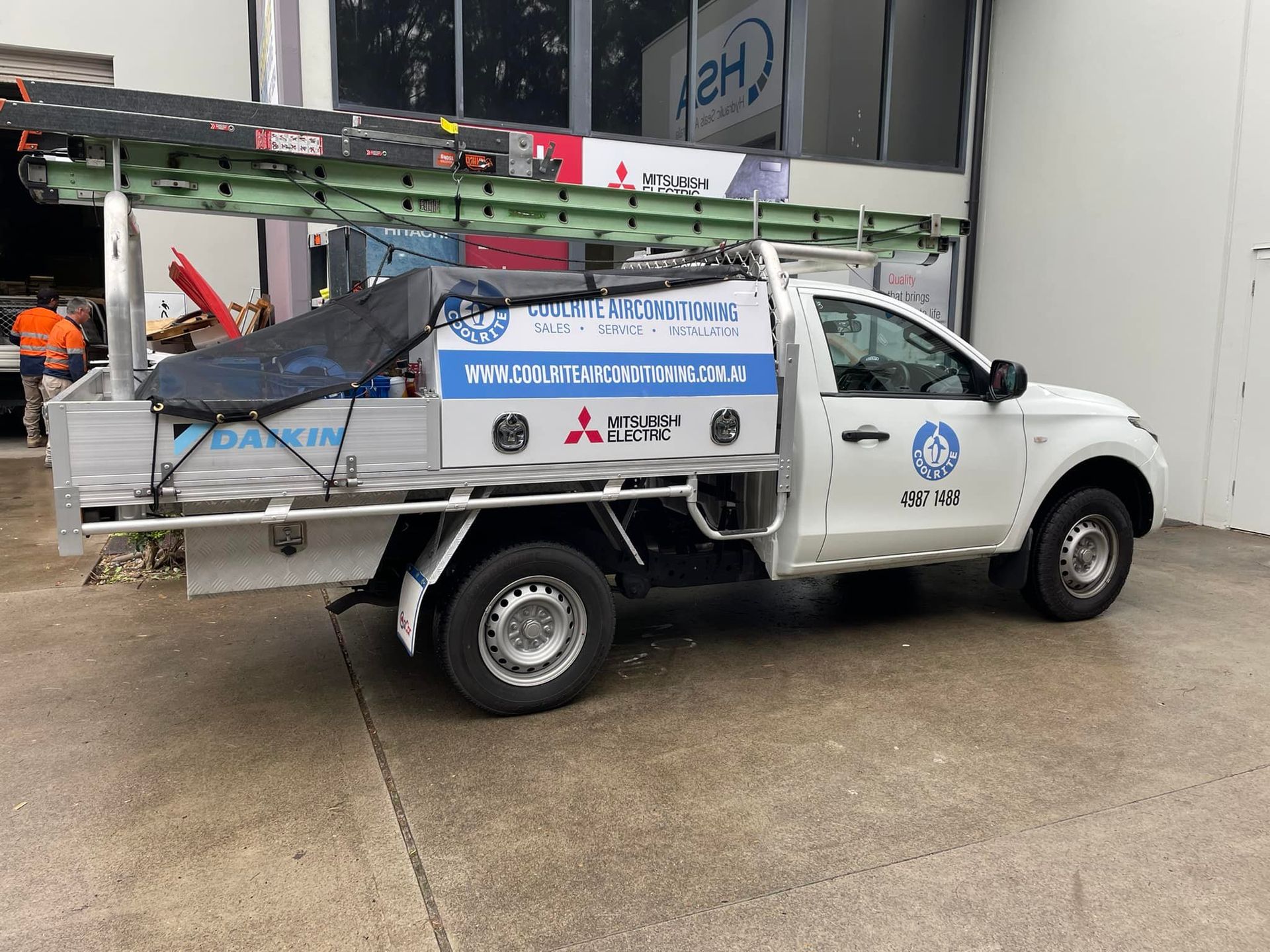 A white truck with a ladder on the back is parked in front of a building — Air Conditioning Installer Hunter Valley