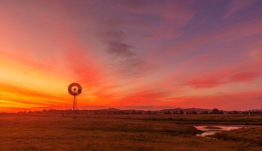 There is a windmill in the middle of a field at sunset — Air Conditioning Maitland