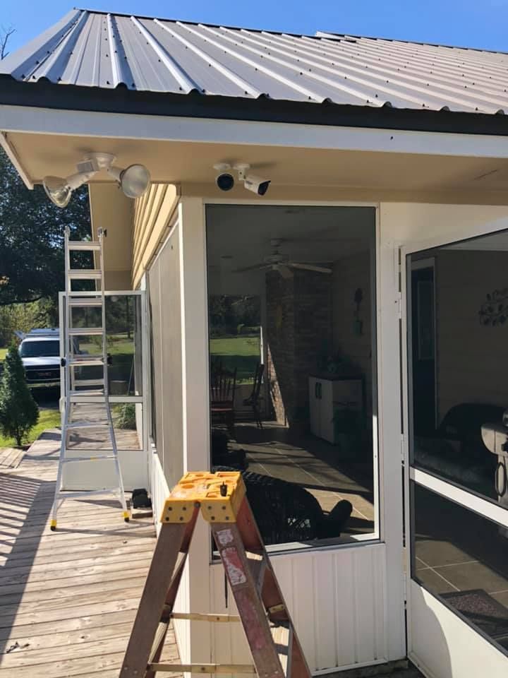 Ladder beside a porch with a metal roof, security cameras mounted overhead.