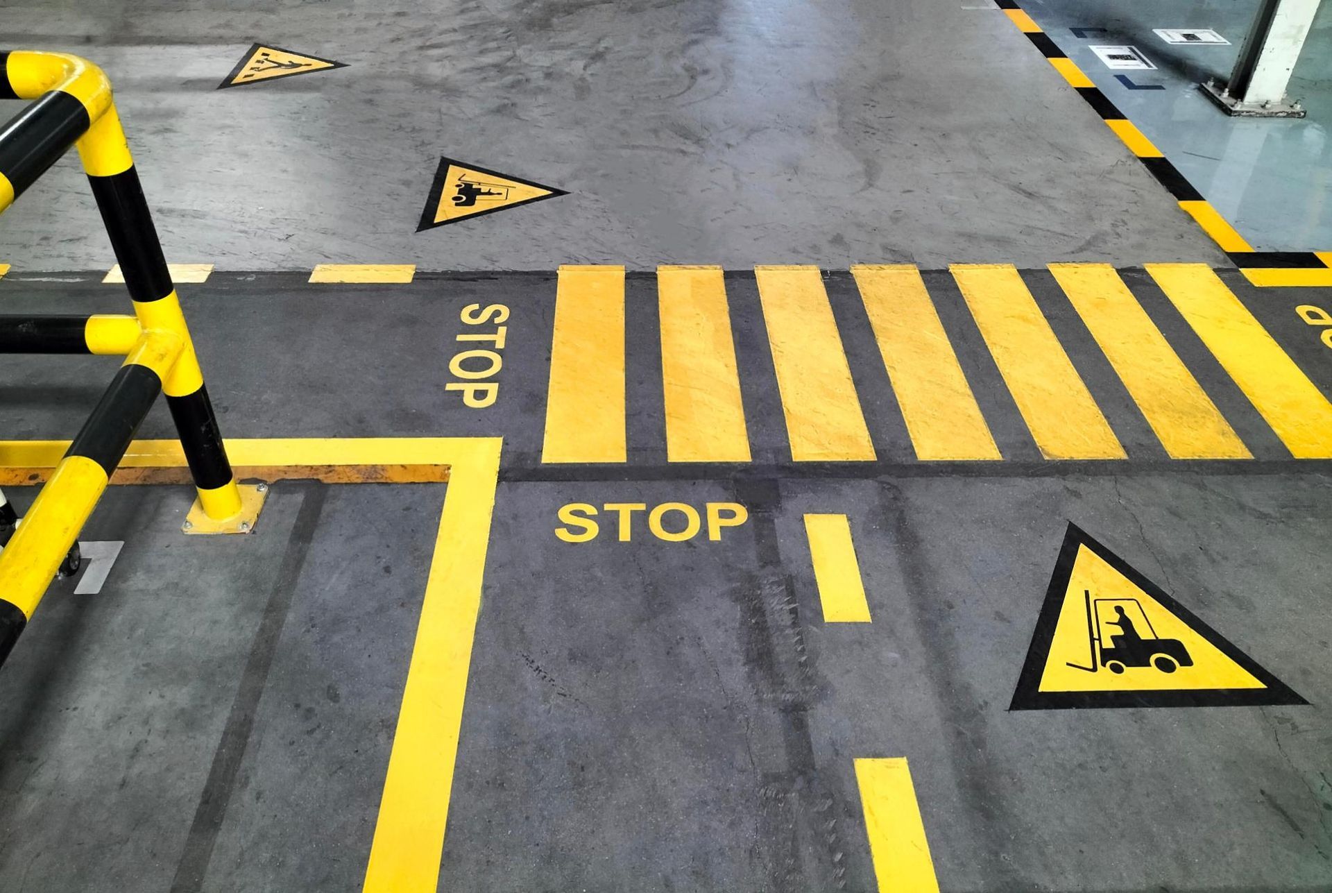 Warehouse floor markings with yellow crosswalk stripes, 