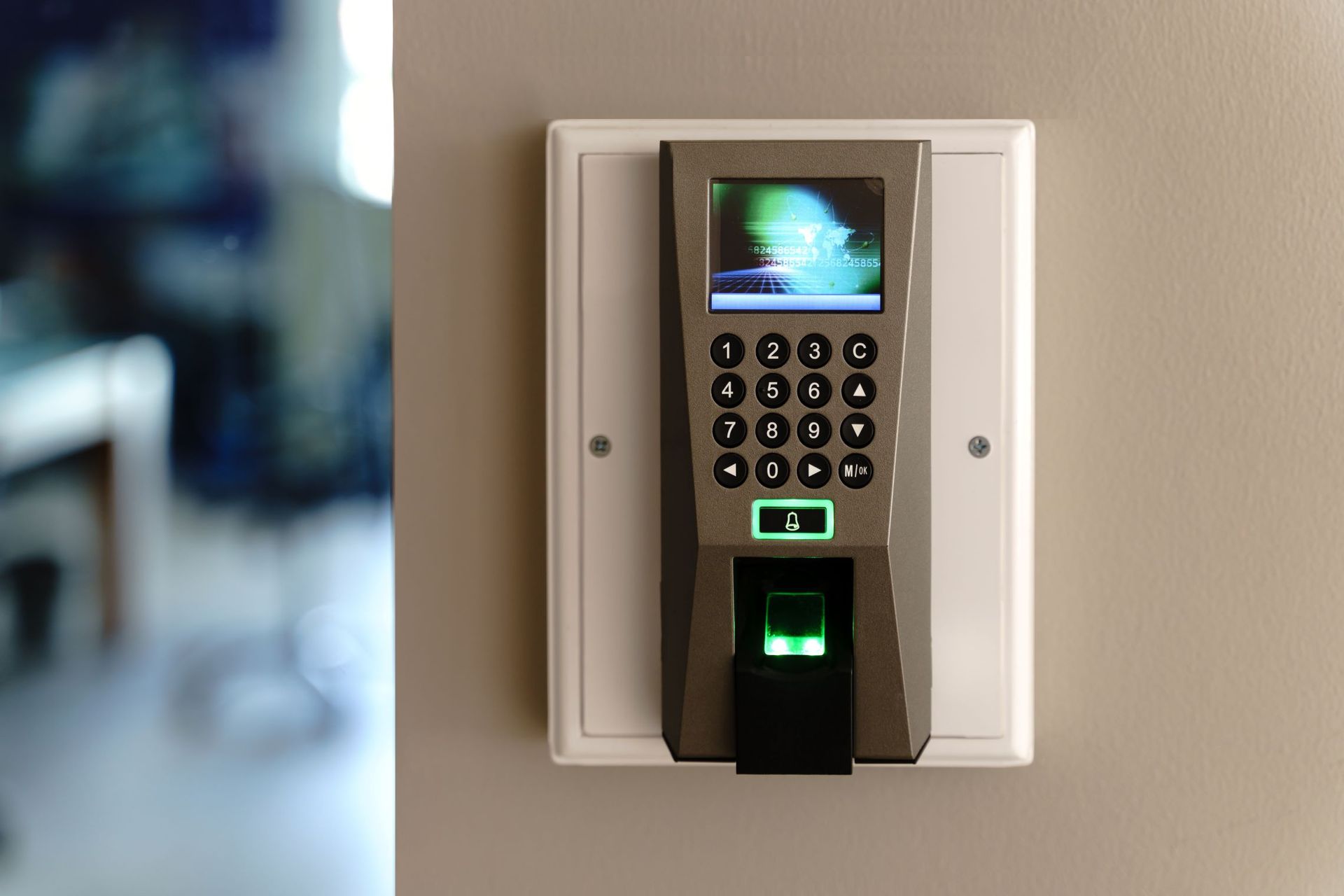 A Fingerprint Scanner Is Mounted On A White Wall