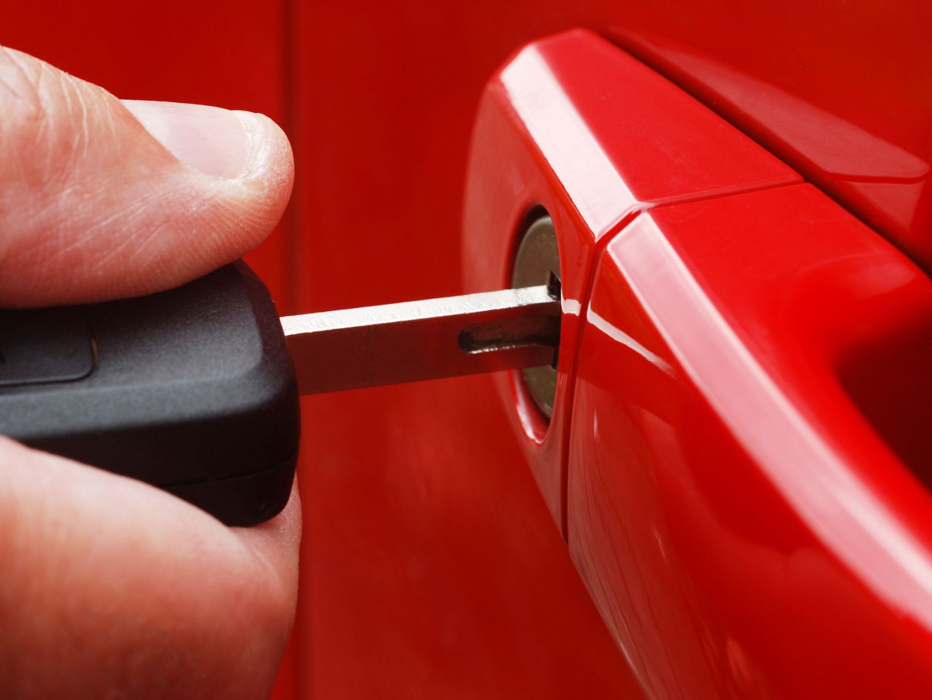 A Person Is Opening A Red Car Door With A Key