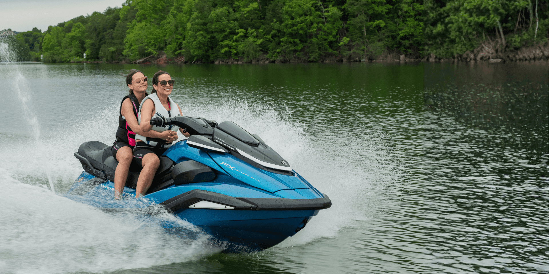 Um jet ski turquesa e branco em águas calmas perto de uma costa verdejante.