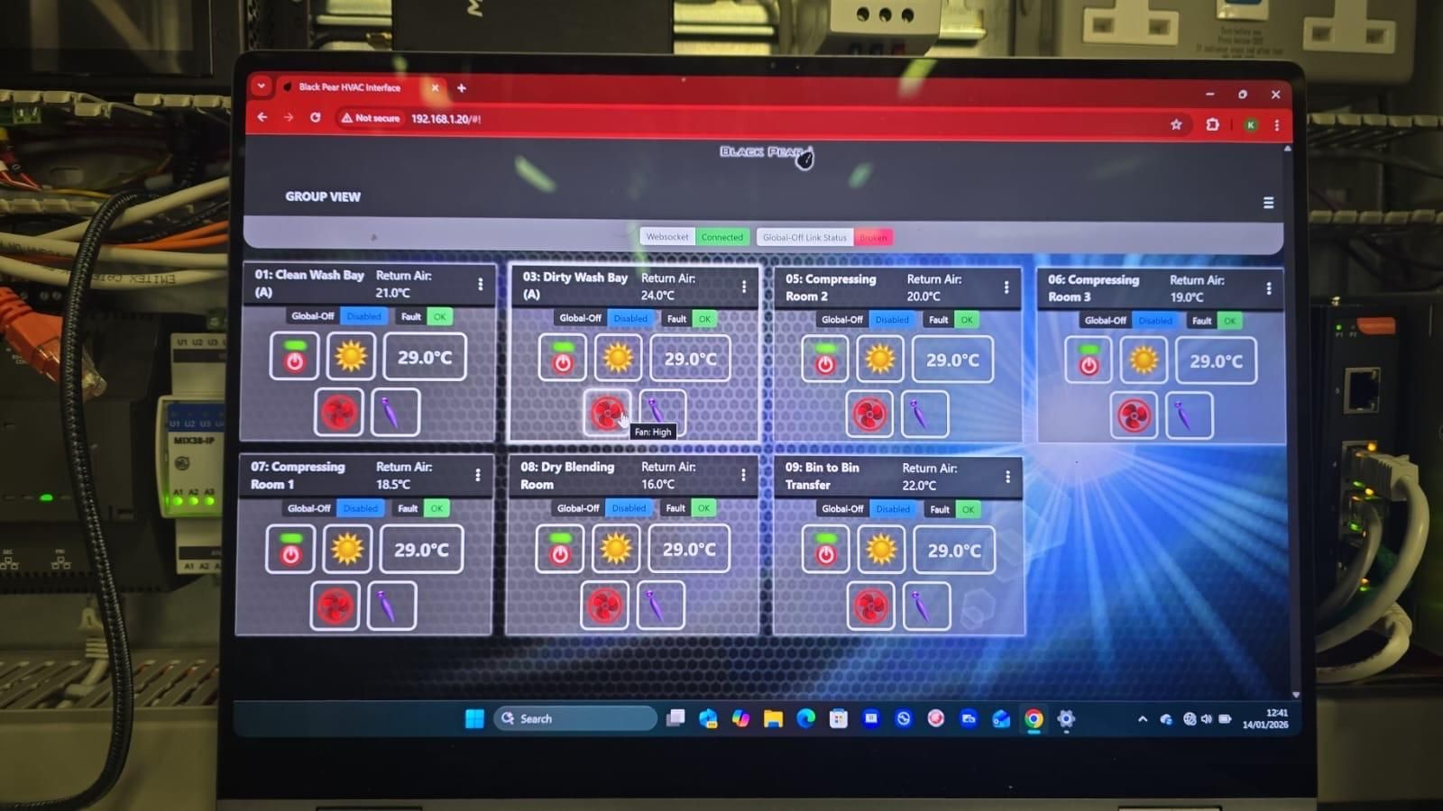 Laptop screen showing a red-and-blue control dashboard with multiple status panels and icons