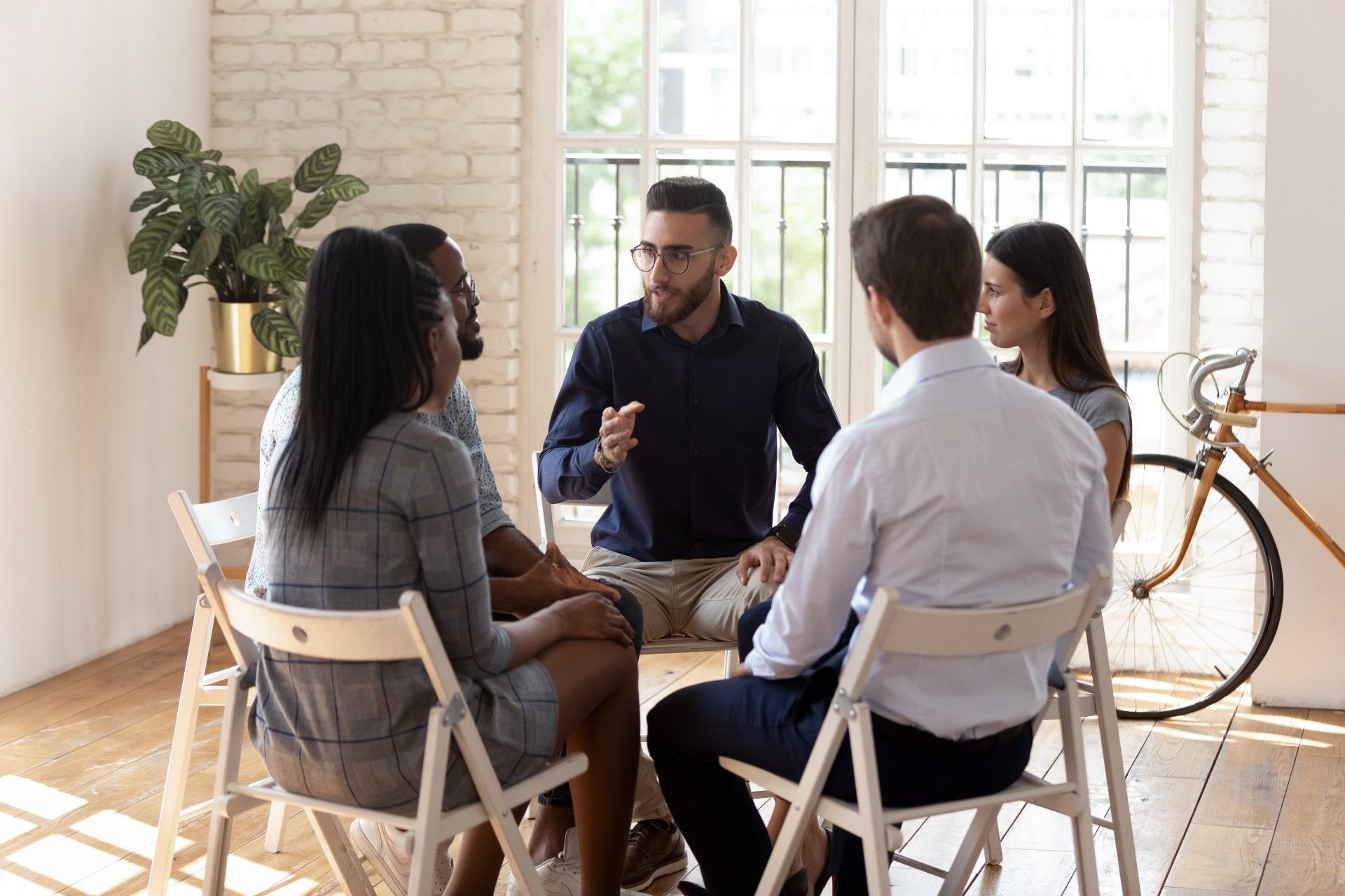A group of people are sitting in a circle talking to each other.