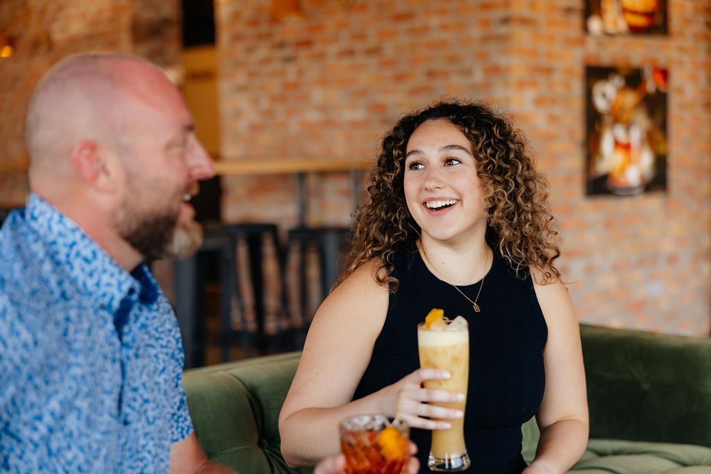 Two People Drinking Cocktails From Six Mile Ordinary in Columbia, MO