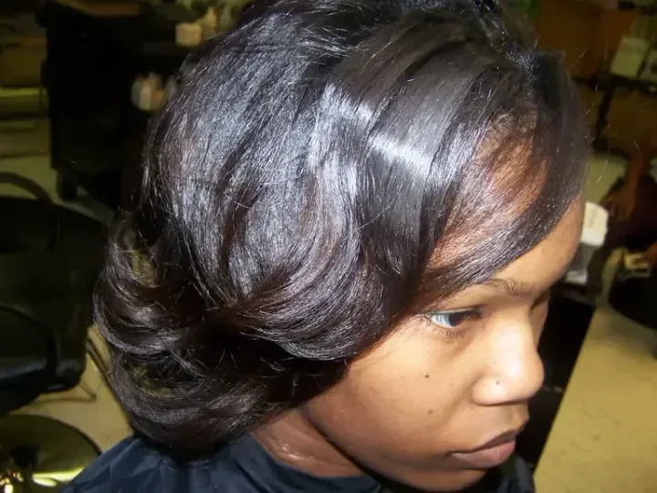 Close-up side profile of a woman with dark hair in an indoor setting