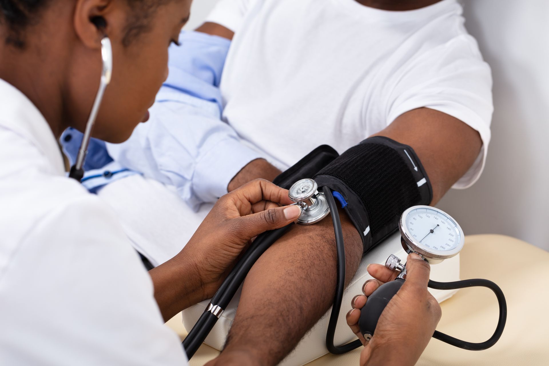 Blood pressure being measured on a patient’s arm with a cuff and stethoscope.