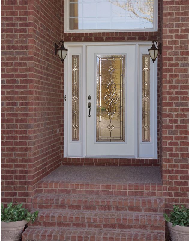 Front entrance with white double doors, glass panels, brick steps, and brick walls