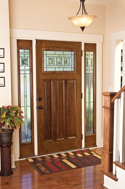 Front entryway with a wooden front door, sidelights, and a striped rug on hardwood floors