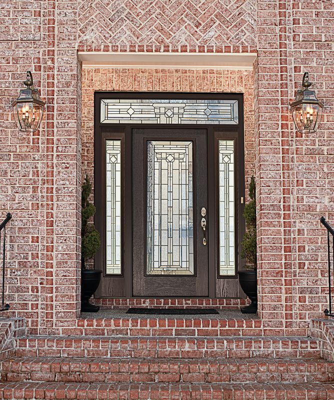 Brick front entry with dark double doors, glass sidelights, and steps up to the doorway