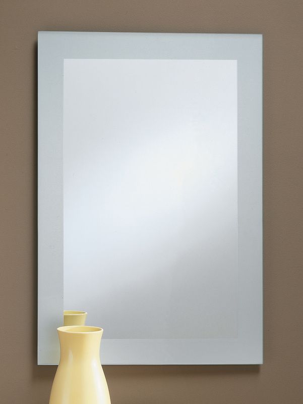 A blank silver-framed mirror above a small yellow vase on a brown surface.